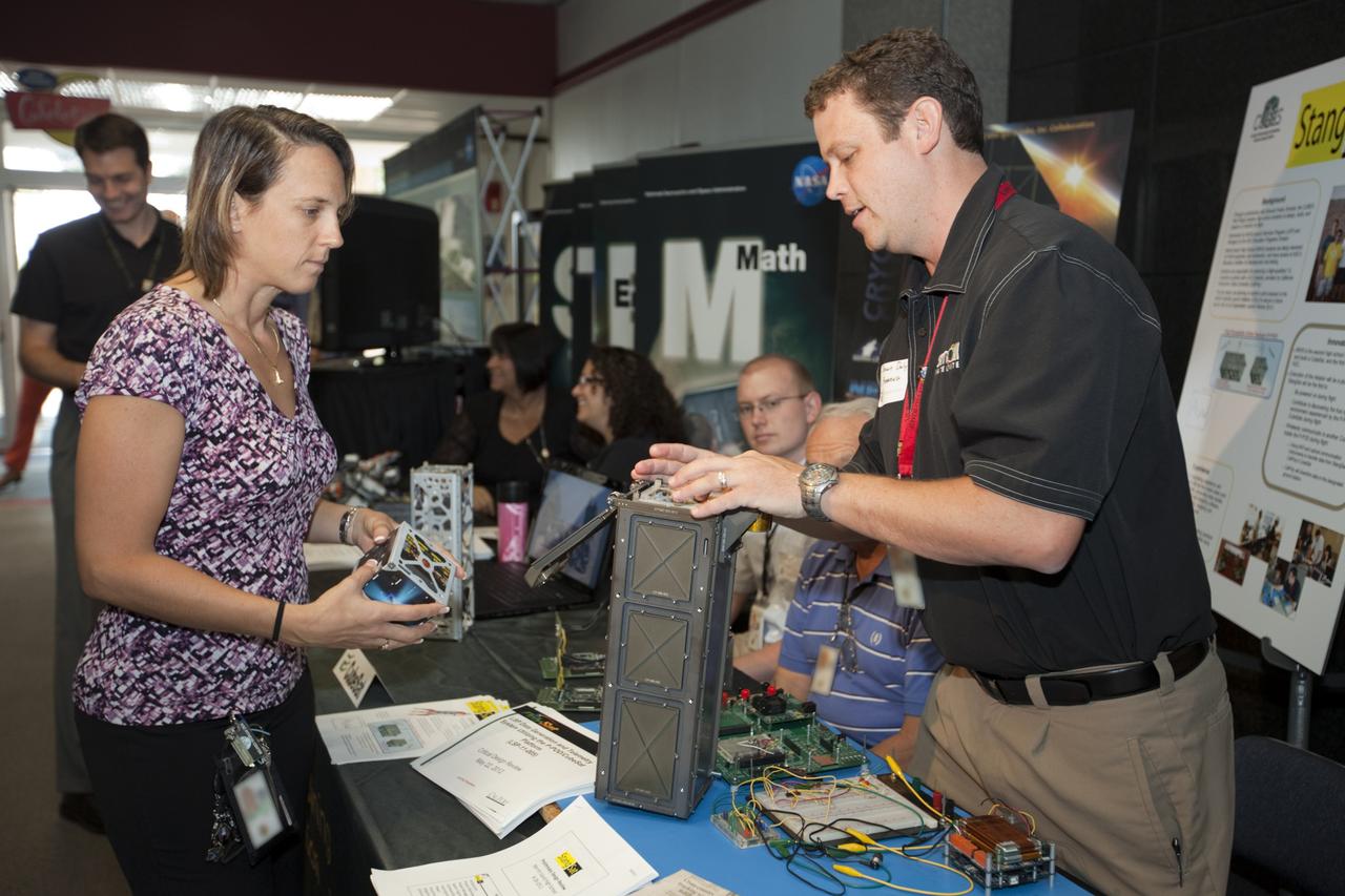 CAPE CANAVERAL, Fla. – At NASA’s Kennedy Space Center in Florida, a worker views an exhibit on small satellite technology in the Headquarters lobby during the center’s 2012 Innovation Expo.    The center-wide event gave researchers a chance to show some of their work to others at the center and gave employees the opportunity to see facilities they hadn’t seen before. Photo credit: NASA/Kim Shiflett