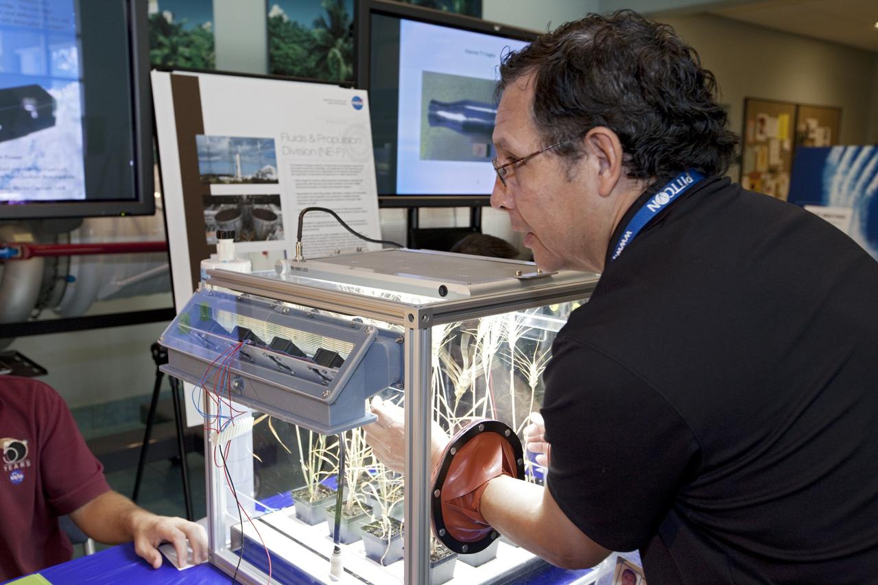CAPE CANAVERAL, Fla. – At NASA’s Kennedy Space Center in Florida, a worker gets hands-on experience with a plant experiment in the Operations and Support Building II during the center’s 2012 Innovation Expo.    The center-wide event gave researchers a chance to show some of their work to others at the center and gave employees the opportunity to see facilities they hadn’t seen before. Photo credit: NASA/Kim Shiflett