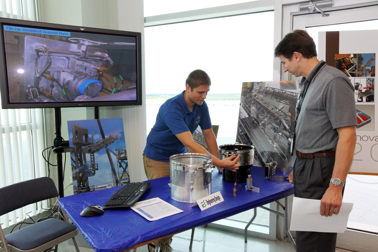CAPE CANAVERAL, Fla. – At NASA’s Kennedy Space Center in Florida, a worker views an exhibit on engineering designs in the Operations and Support Building II during the center’s 2012 Innovation Expo.    The center-wide event gave researchers a chance to show some of their work to others at the center and gave employees the opportunity to see facilities they hadn’t seen before. Photo credit: NASA/Kim Shiflett