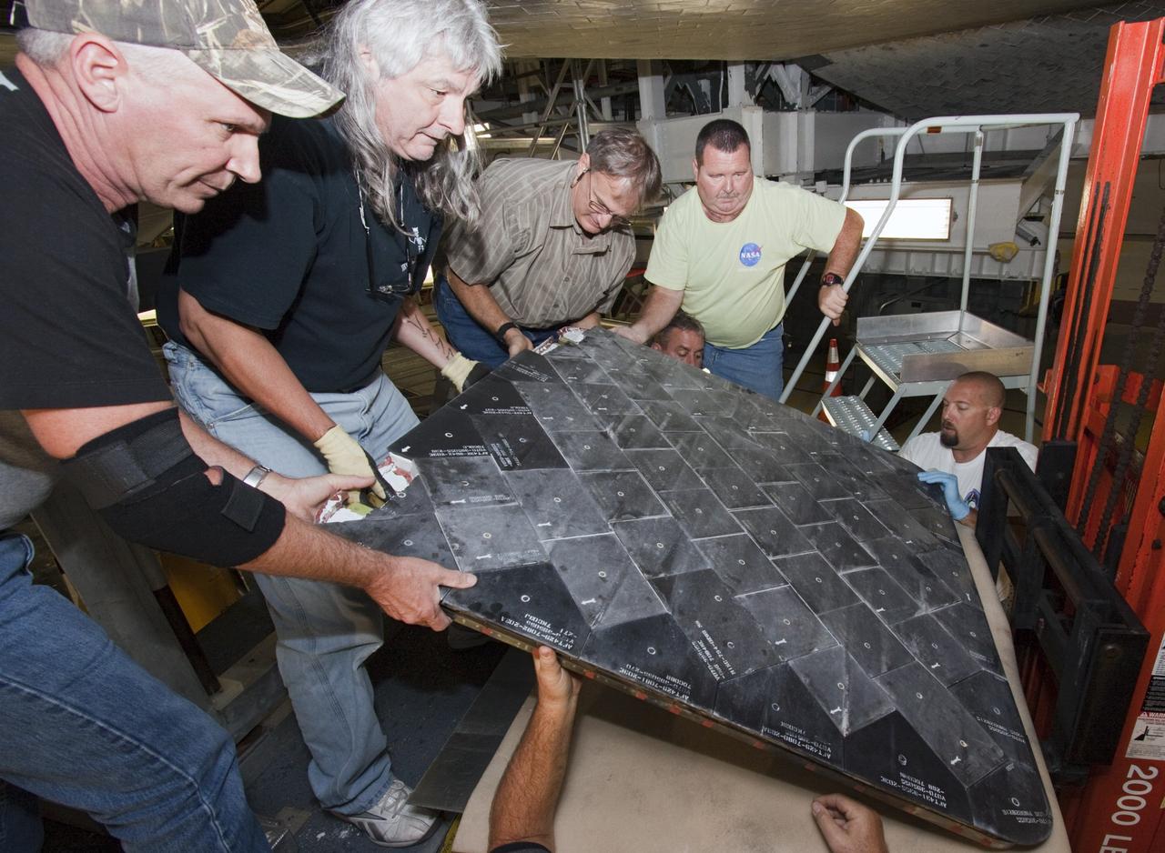 CAPE CANAVERAL, Fla. – In Bay 2 of the Orbiter Processing Facility at NASA's Kennedy Space Center in Florida, United Space Alliance technicians remove the two external fuel tank doors from the space shuttle Atlantis. The orbiter is undergoing final preparations for its transfer to the Kennedy Space Center Visitor Complex targeted for November. The work is part of Transition and Retirement of the remaining space shuttles, Atlantis and Endeavour. Atlantis is being prepared for public display at Kennedy's Visitor Complex. Over the course of its 26-year career, Atlantis spent 293 days in space during 33 missions. For more information, visit http://www.nasa.gov/transition Photo credit: NASA/Jim Grossmann