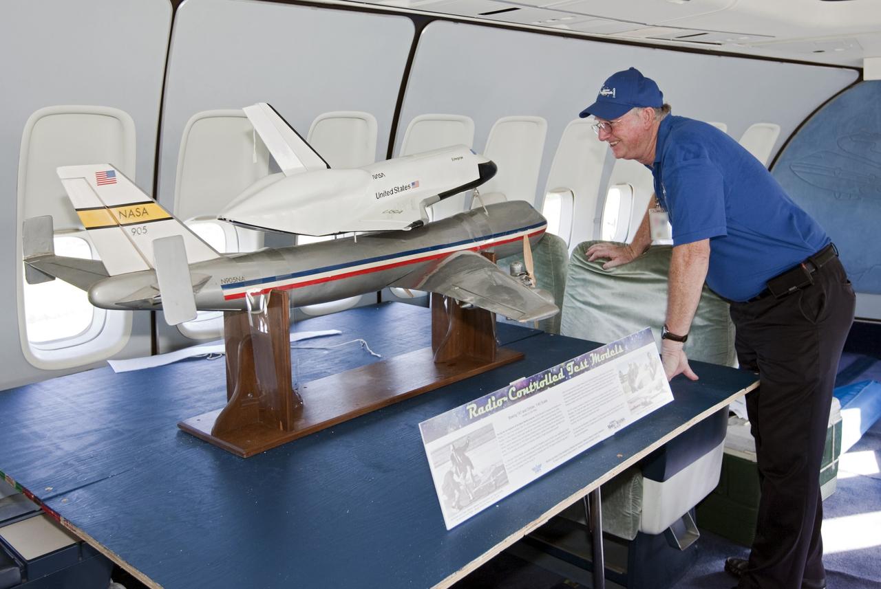 CAPE CANAVERAL, Fla. – A visitor looks over a model of the Shuttle Carrier Aircraft, or SCA, and a space shuttle during a tour of the real Shuttle Carrier Aircraft. The model is a radio-controlled scale version of the modified 747 that was used to test theories for how the space shuttle would separate from the SCA during approach and landing tests. Photo credit: NASA/Kim Shiflett