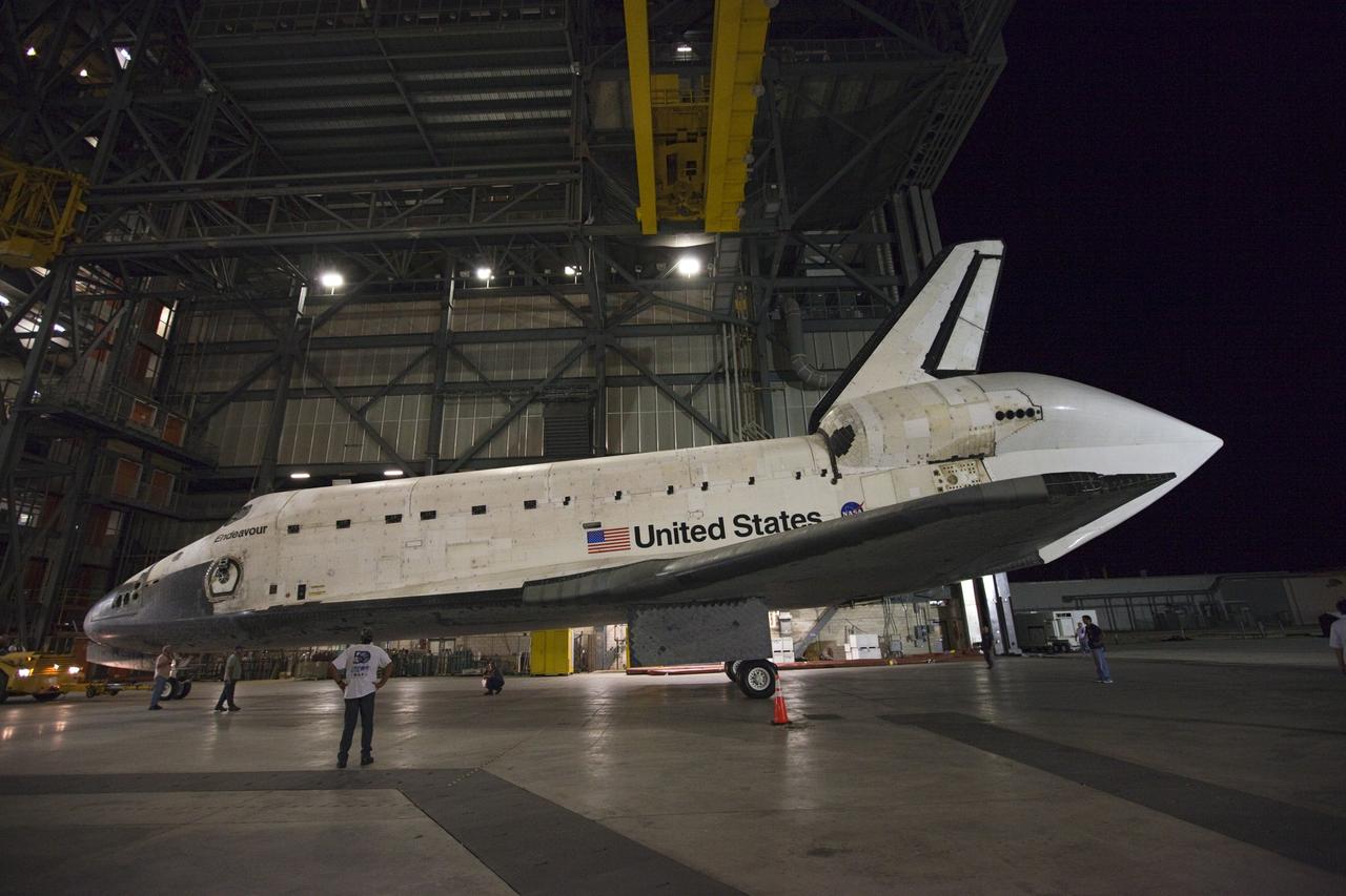 CAPE CANAVERAL, Fla. – Employees stand watch as space shuttle Endeavour, fitted with an aerodynamic tail cone, backs out of the Vehicle Assembly Building at NASA's Kennedy Space Center in Florida. The spacecraft moved to the nearby Shuttle Landing Facility, where it will be lifted in the gantry-like Mate-Demate Device and placed atop NASA's modified 747 Shuttle Carrier Aircraft for the final ferry flight of the Space Shuttle Program. Endeavour will be placed on permanent public display at the California Science Center in Los Angeles. Photo credit: NASA/Kim Shiflett