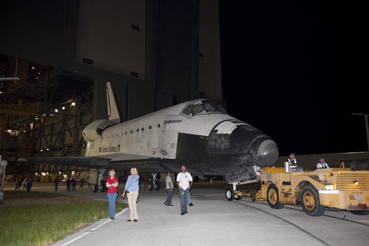 CAPE CANAVERAL, Fla. – Workers escort space shuttle Endeavour as it is towed to the Mate-Demate Device, or MDD, at NASA's Kennedy Space Center in Florida after being backed out of the Vehicle Assembly Building. The MDD is located at the Shuttle Landing Facility at Kennedy. The shuttle will be lifted and connected to the top of NASA's Shuttle Carrier Aircraft SCA, a modified 747 jetliner. The shuttle has been fitted with an aerodynamic tailcone for its flight aboard the SCA to Los Angeles where it will be placed on public display. Photo credit: NASA/Kim Shiflett