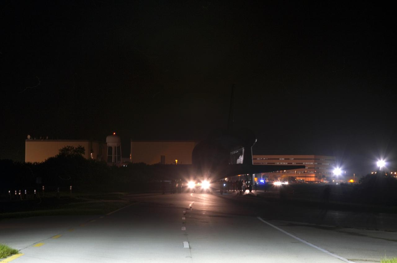 CAPE CANAVERAL, Fla. – Workers escort space shuttle Endeavour as it is towed to the Mate-Demate Device, or MDD, at NASA's Kennedy Space Center in Florida after being backed out of the Vehicle Assembly Building. The MDD is located at the Shuttle Landing Facility at Kennedy. The shuttle will be lifted and connected to the top of NASA's Shuttle Carrier Aircraft SCA, a modified 747 jetliner. The shuttle has been fitted with an aerodynamic tailcone for its flight aboard the SCA to Los Angeles where it will be placed on public display. Photo credit: NASA/ Frankie Martin