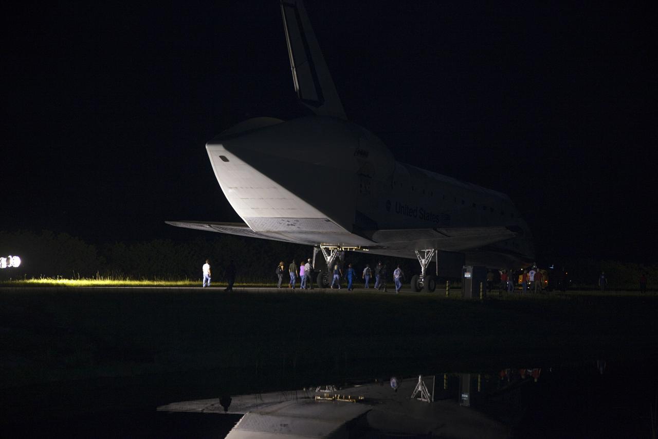 CAPE CANAVERAL, Fla. – Workers escort space shuttle Endeavour as it is towed to the Mate-Demate Device, or MDD, at NASA's Kennedy Space Center in Florida after being backed out of the Vehicle Assembly Building. The MDD is located at the Shuttle Landing Facility at Kennedy. The shuttle will be lifted and connected to the top of NASA's Shuttle Carrier Aircraft SCA, a modified 747 jetliner. The shuttle has been fitted with an aerodynamic tailcone for its flight aboard the SCA to Los Angeles where it will be placed on public display. Photo credit: NASA/ Frankie Martin