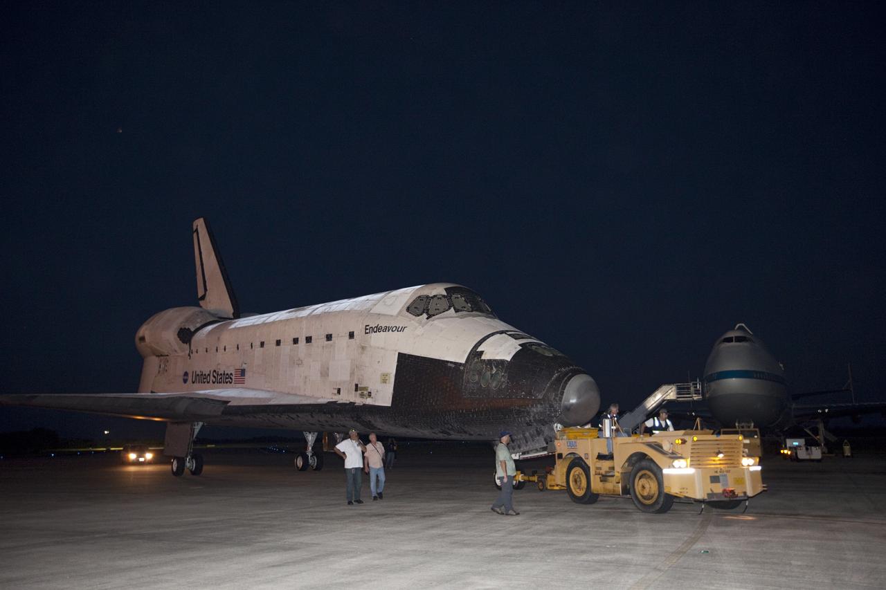 CAPE CANAVERAL, Fla. – Workers watch the arrival of space shuttle Endeavour at the Shuttle Landing Facility after the shuttle was towed from the Vehicle Assembly Building at NASA's Kennedy Space Center in Florida. Endeavour was towed to the Mate-Demate Device, or MDD, where the shuttle will be lifted and connected to the top of NASA's Shuttle Carrier Aircraft SCA, a modified 747 jetliner. The shuttle has been fitted with an aerodynamic tailcone for its flight aboard the SCA to Los Angeles where it will be placed on public display. Photo credit: NASA/Kim Shiflett