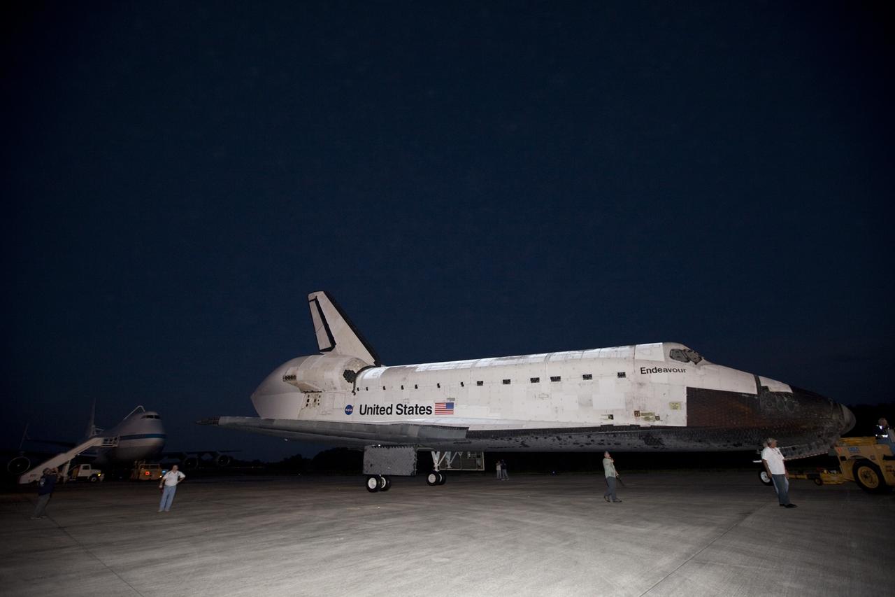 CAPE CANAVERAL, Fla. – Workers watch the arrival of space shuttle Endeavour at the Shuttle Landing Facility after the shuttle was towed from the Vehicle Assembly Building at NASA's Kennedy Space Center in Florida. Endeavour was towed to the Mate-Demate Device, or MDD, where the shuttle will be lifted and connected to the top of NASA's Shuttle Carrier Aircraft SCA, a modified 747 jetliner. The shuttle has been fitted with an aerodynamic tailcone for its flight aboard the SCA to Los Angeles where it will be placed on public display. Photo credit: NASA/Kim Shiflett