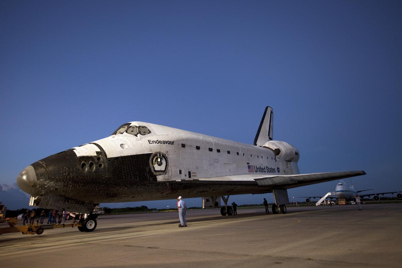 CAPE CANAVERAL, Fla. – Workers watch the arrival of space shuttle Endeavour at the Shuttle Landing Facility after the shuttle was towed from the Vehicle Assembly Building at NASA's Kennedy Space Center in Florida. Endeavour was towed to the Mate-Demate Device, or MDD, where the shuttle will be lifted and connected to the top of NASA's Shuttle Carrier Aircraft SCA, a modified 747 jetliner. The shuttle has been fitted with an aerodynamic tailcone for its flight aboard the SCA to Los Angeles where it will be placed on public display. Photo credit: NASA/Kim Shiflett