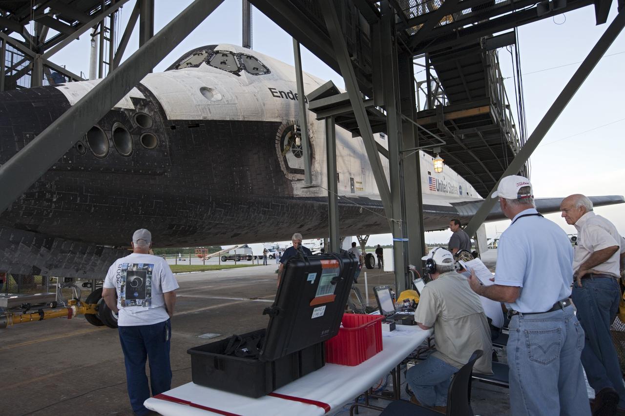 CAPE CANAVERAL, Fla. – Workers watch as space shuttle Endeavour is towed into the Mate-Demate Device, or MDD, at NASA's Kennedy Space Center in Florida. The MDD will be used to lift and connect the shuttle to the top of NASA's Shuttle Carrier Aircraft SCA, a modified 747 jetliner. The shuttle has been fitted with an aerodynamic tailcone for its flight aboard the SCA to Los Angeles where it will be placed on public display. The shuttle was towed from the Vehicle Assembly Building. Photo credit: NASA/Kim Shiflett