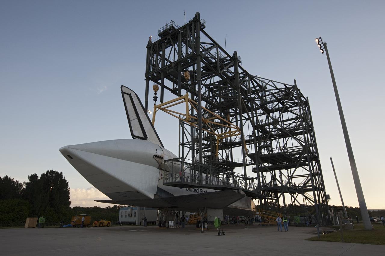 CAPE CANAVERAL, Fla. – Workers watch as space shuttle Endeavour is towed into the Mate-Demate Device, or MDD, at NASA's Kennedy Space Center in Florida. The MDD will be used to lift and connect the shuttle to the top of NASA's Shuttle Carrier Aircraft SCA, a modified 747 jetliner. The shuttle has been fitted with an aerodynamic tailcone for its flight aboard the SCA to Los Angeles where it will be placed on public display. The shuttle was towed from the Vehicle Assembly Building. Photo credit: NASA/Kim Shiflett