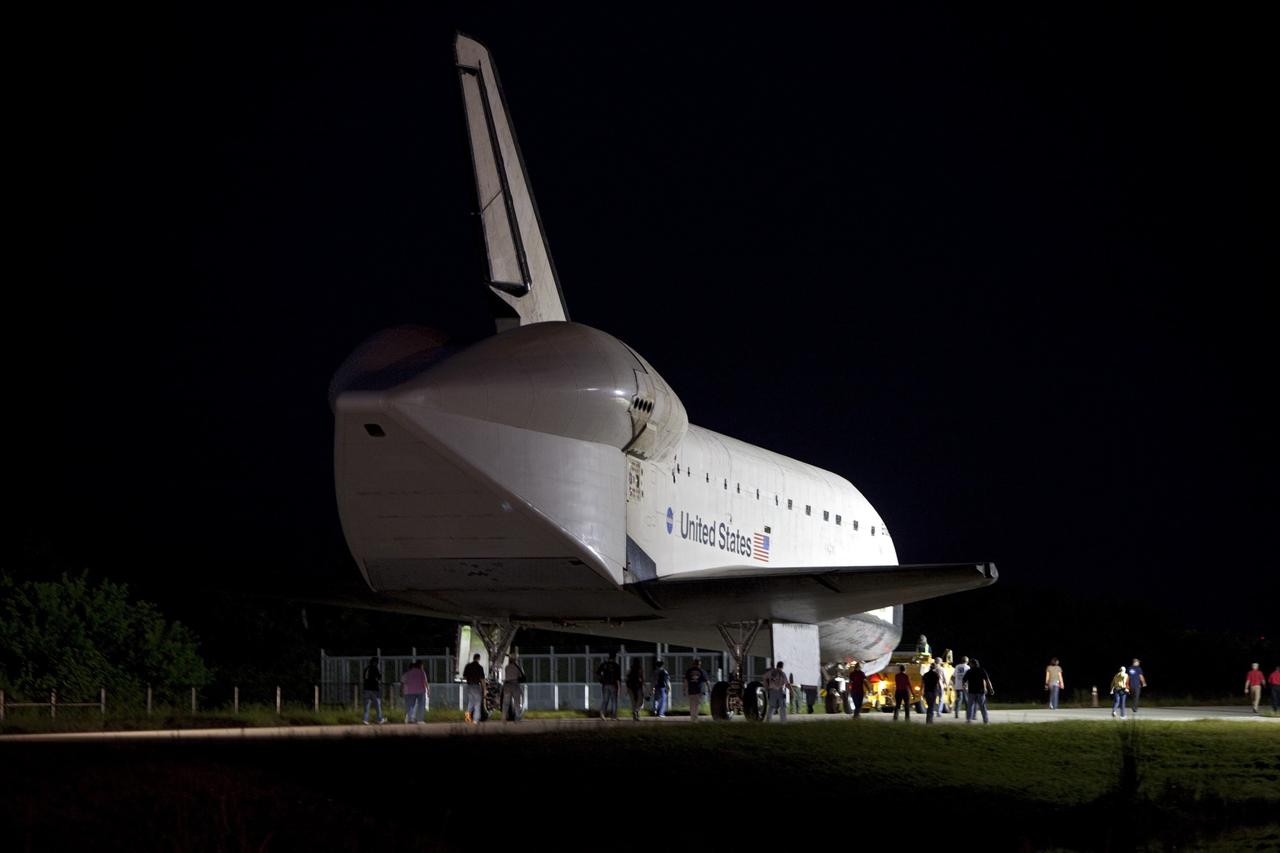CAPE CANAVERAL, Fla. - Workers escort space shuttle Endeavour as it is towed to the Mate-Demate Device, or MDD, at NASA's Kennedy Space Center in Florida after being backed out of the Vehicle Assembly Building. The MDD is located at the Shuttle Landing Facility at Kennedy. The shuttle will be lifted and connected to the top of NASA's Shuttle Carrier Aircraft SCA, a modified 747 jetliner. The shuttle has been fitted with an aerodynamic tailcone for its flight aboard the SCA to Los Angeles where it will be placed on public display. Photo credit: NASA/Dmitri Gerondidakis