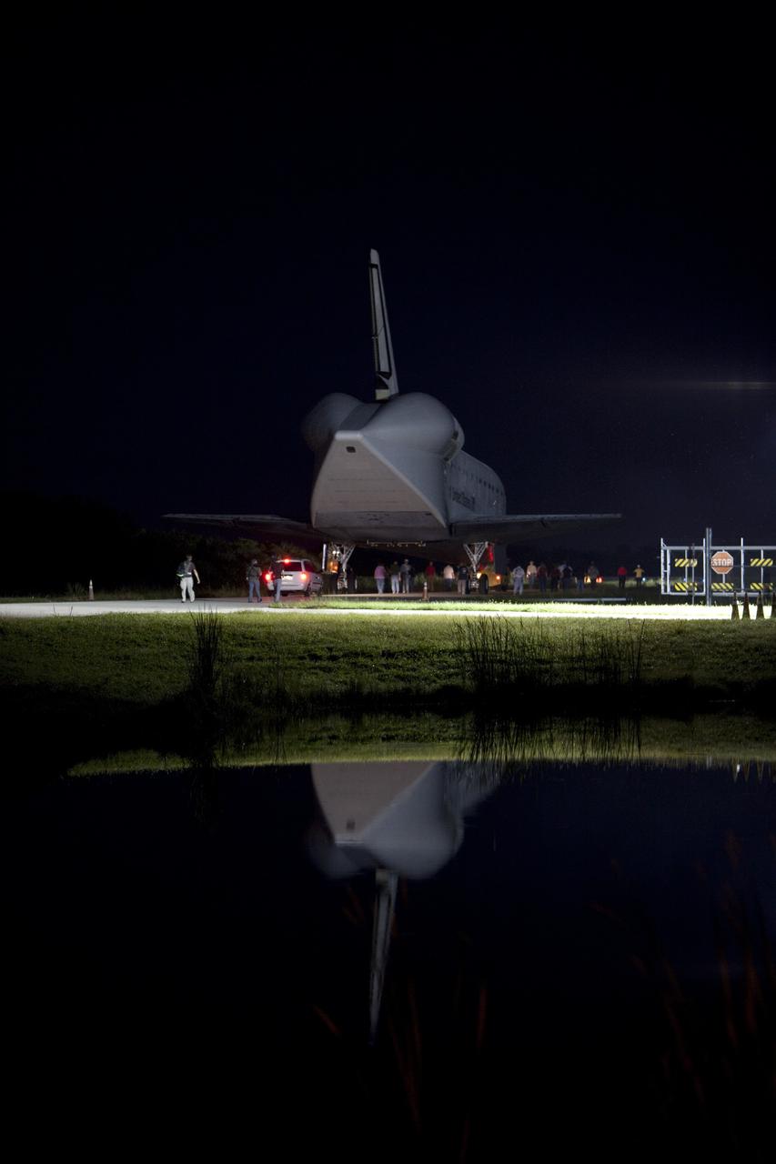 CAPE CANAVERAL, Fla. - Workers escort space shuttle Endeavour as it is towed to the Mate-Demate Device, or MDD, at NASA's Kennedy Space Center in Florida after being backed out of the Vehicle Assembly Building. The MDD is located at the Shuttle Landing Facility at Kennedy. The shuttle will be lifted and connected to the top of NASA's Shuttle Carrier Aircraft SCA, a modified 747 jetliner. The shuttle has been fitted with an aerodynamic tailcone for its flight aboard the SCA to Los Angeles where it will be placed on public display. Photo credit: NASA/Dmitri Gerondidakis