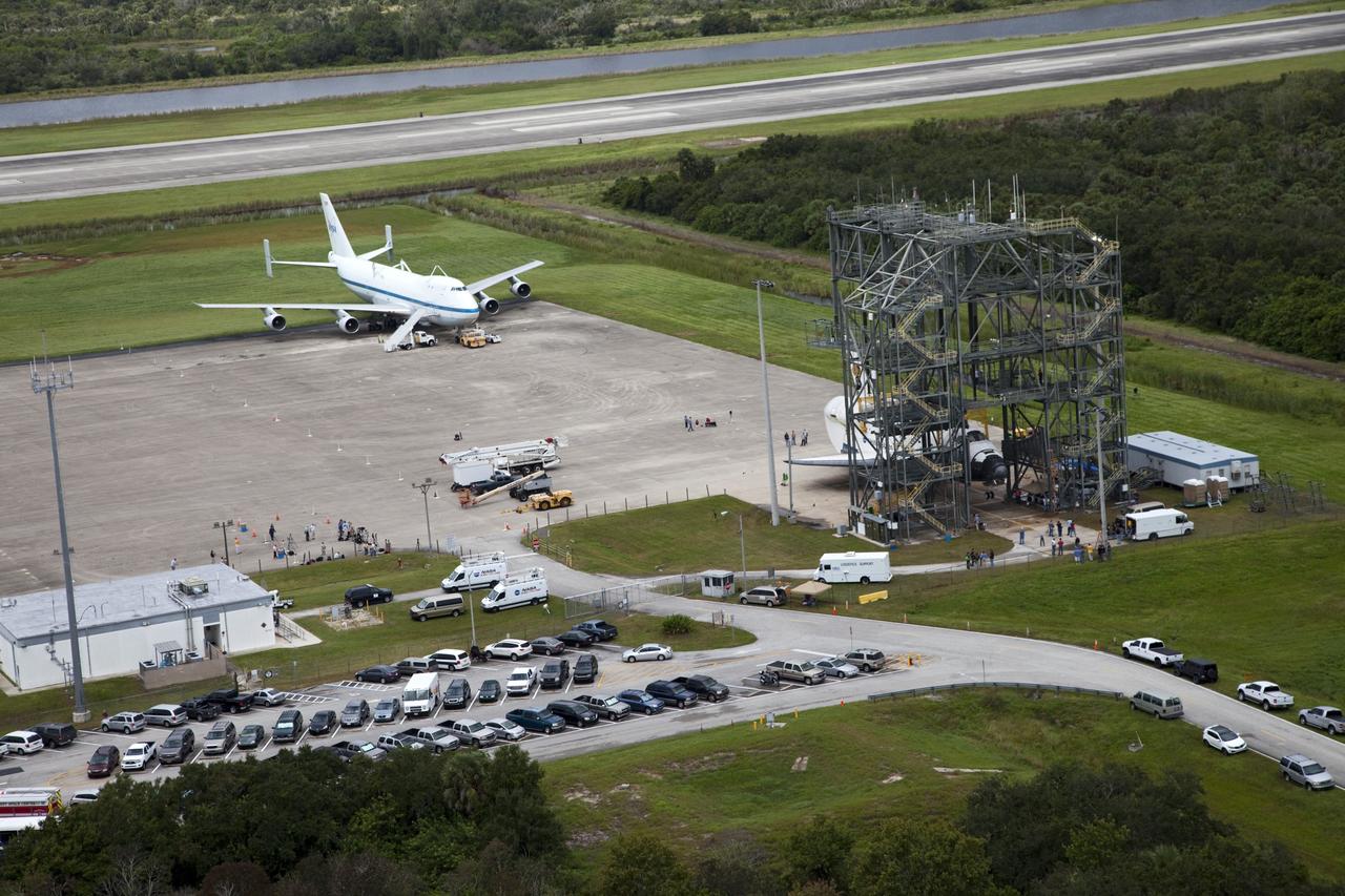 CAPE CANAVERAL, Fla. – Space shuttle Endeavour is seen inside the Mate-Demate Device, or MDD, at the Shuttle Landing Facility at NASA's Kennedy Space Center in Florida. The Shuttle Carrier Aircraft, or SCA, is seen on the ramp. The SCA will carry Endeavour to Los Angeles where it will be placed on public display. Photo credit: NASA/Kim Shiflett