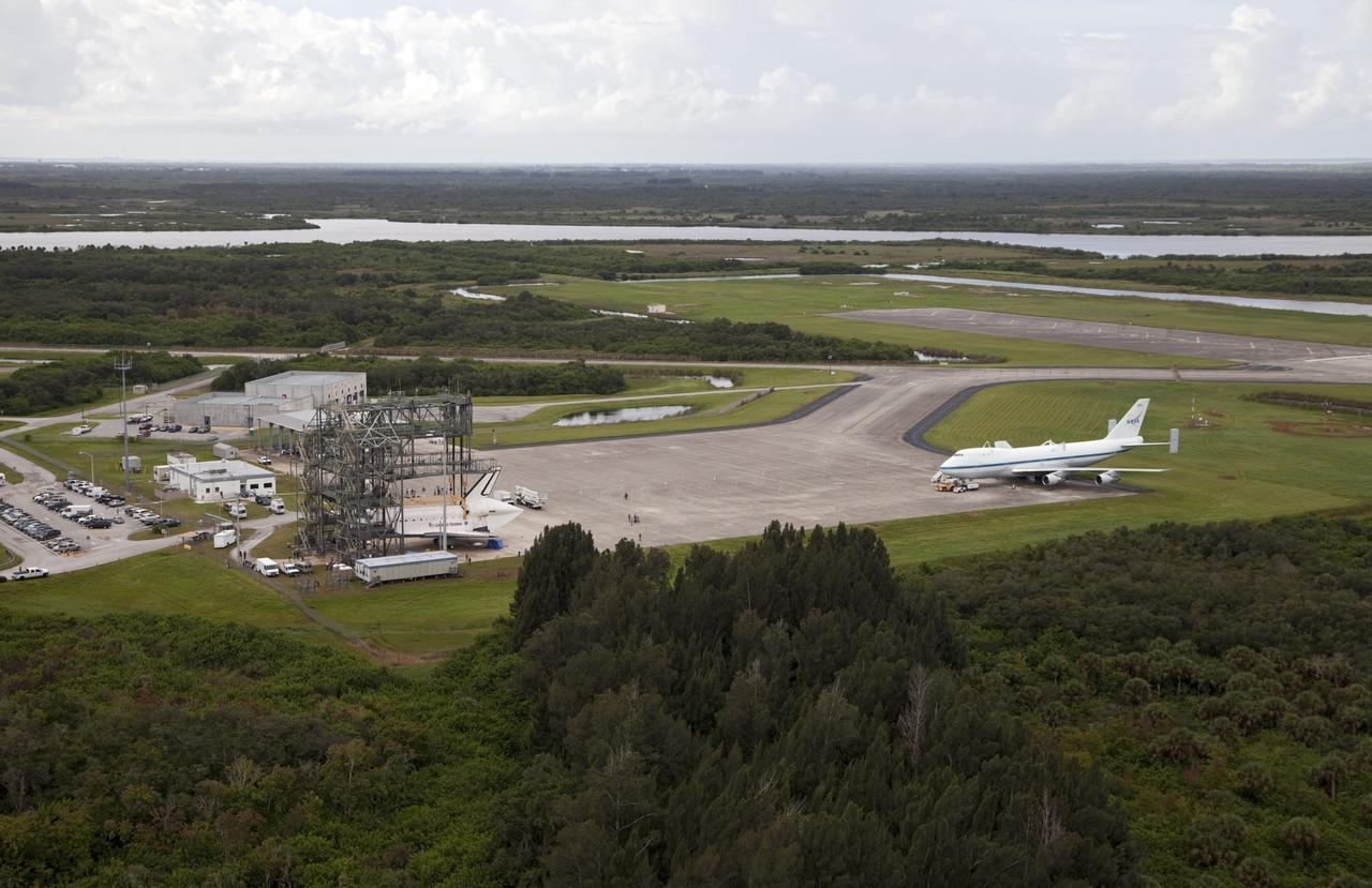 CAPE CANAVERAL, Fla. – Space shuttle Endeavour is seen inside the Mate-Demate Device, or MDD, at the Shuttle Landing Facility at NASA's Kennedy Space Center in Florida. The Shuttle Carrier Aircraft, or SCA, is seen on the ramp. The SCA will carry Endeavour to Los Angeles where it will be placed on public display. The center's Vehicle Assembly Building, or VAB, and the mobile launcher built for the Space Launch System are also visible in the background. Photo credit: NASA/Kim Shiflett