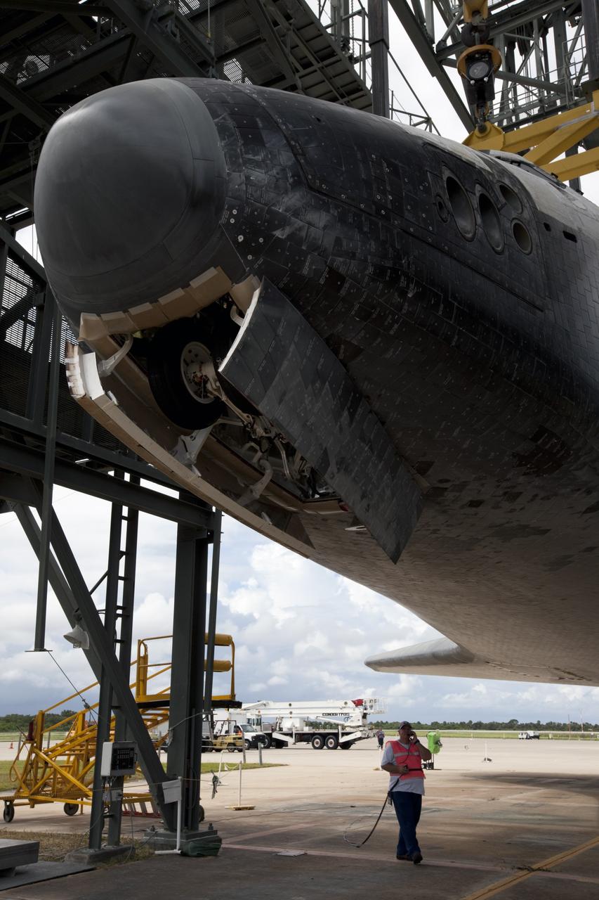 CAPE CANAVERAL, Fla. – A United Space Alliance technician monitors space shuttle Endeavour as it is lifted into the mate-demate device at the Shuttle Landing Facility at NASA's Kennedy Space Center in Florida. The shuttle will be positioned and connected to the top of NASA's Shuttle Carrier Aircraft, or SCA, with the aid of the device. The SCA, a modified 747 jetliner, will fly Endeavour to Los Angeles where it will be placed on public display at the California Science Center. This is the final ferry flight scheduled in the Space Shuttle Program era. For more information on the shuttles' transition and retirement, visit http://www.nasa.gov/transition. Photo credit: NASA/Kim Shiflett