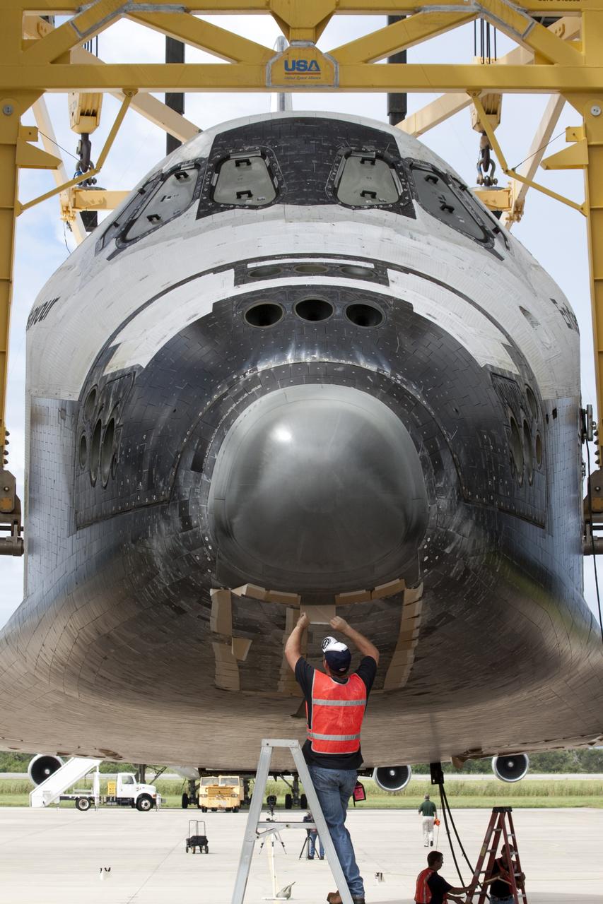 CAPE CANAVERAL, Fla. – A United Space Alliance technician secures the doors on space shuttle Endeavour's nose gear as it is lifted into the mate-demate device at the Shuttle Landing Facility at NASA's Kennedy Space Center in Florida. The shuttle will be positioned and connected to the top of NASA's Shuttle Carrier Aircraft, or SCA, with the aid of the device. The SCA, a modified 747 jetliner, will fly Endeavour to Los Angeles where it will be placed on public display at the California Science Center. This is the final ferry flight scheduled in the Space Shuttle Program era. For more information on the shuttles' transition and retirement, visit http://www.nasa.gov/transition. Photo credit: NASA/Kim Shiflett