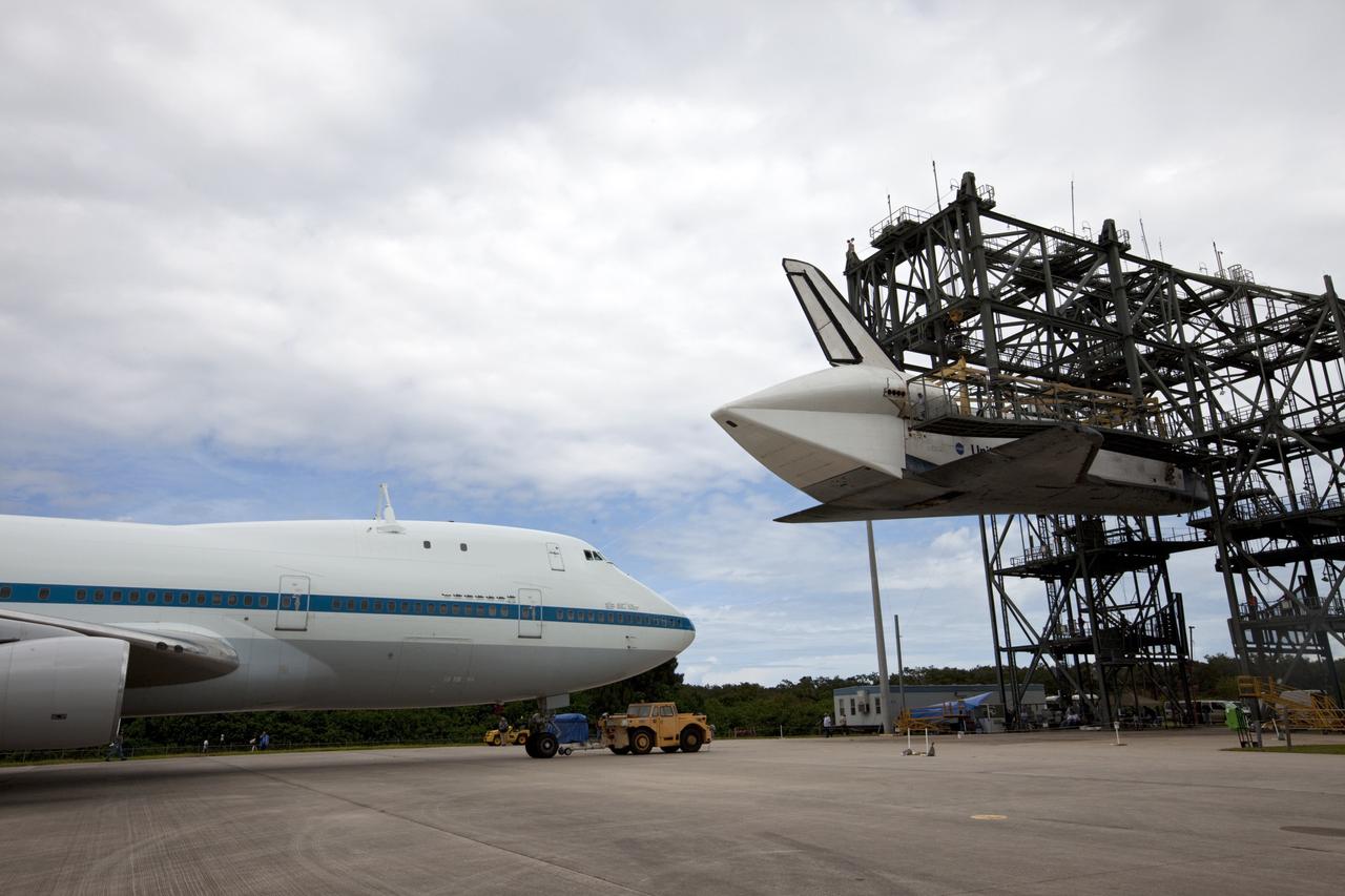 CAPE CANAVERAL, Fla. – NASA's Shuttle Carrier Aircraft, or SCA, rolls beneath space shuttle Endeavour, suspended in the mate-demate device at the Shuttle Landing Facility at NASA's Kennedy Space Center in Florida. The shuttle will be lowered and connected to the top of the SCA with the aid of the device. The shuttle has been fitted with an aerodynamic tailcone for its upcoming ferry flight. The SCA, a modified 747 jetliner, will fly Endeavour to Los Angeles where it will be placed on public display at the California Science Center. This is the final ferry flight scheduled in the Space Shuttle Program era. For more information on the shuttles' transition and retirement, visit http://www.nasa.gov/transition. Photo credit: NASA/Kim Shiflett