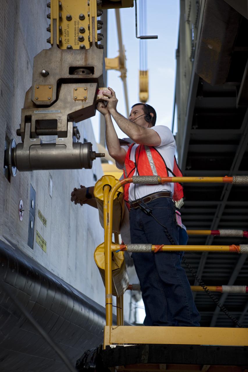 CAPE CANAVERAL, Fla. – A United Space Alliance technician attaches space shuttle Endeavour to the mate-demate device at the Shuttle Landing Facility at NASA's Kennedy Space Center in Florida. The shuttle will be positioned and connected to the top of NASA's Shuttle Carrier Aircraft, or SCA, with the aid of the device. The SCA, a modified 747 jetliner, will fly Endeavour to Los Angeles where it will be placed on public display at the California Science Center. This is the final ferry flight scheduled in the Space Shuttle Program era. For more information on the shuttles' transition and retirement, visit http://www.nasa.gov/transition. Photo credit: NASA/Dimitri Gerondidakis