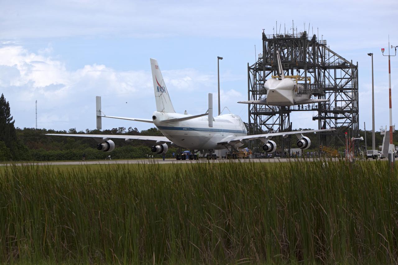 CAPE CANAVERAL, Fla. – NASA's Shuttle Carrier Aircraft, or SCA, rolls toward space shuttle Endeavour, suspended in the mate-demate device at the Shuttle Landing Facility at NASA's Kennedy Space Center in Florida. The shuttle will be lowered and connected to the top of the SCA with the aid of the device. The shuttle has been fitted with an aerodynamic tailcone for its upcoming ferry flight. The SCA, a modified 747 jetliner, will fly Endeavour to Los Angeles where it will be placed on public display at the California Science Center. This is the final ferry flight scheduled in the Space Shuttle Program era. For more information on the shuttles' transition and retirement, visit http://www.nasa.gov/transition. Photo credit: NASA/Dimitri Gerondidakis