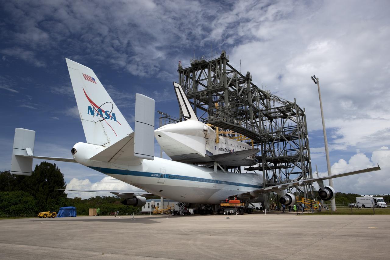CAPE CANAVERAL, Fla. – United Space Alliance technicians watch as space shuttle Endeavour is lowered onto the Shuttle Carrier Aircraft, or SCA, at the Shuttle Landing Facility at NASA's Kennedy Space Center in Florida. The SCA, a modified 747 jetliner, will fly Endeavour to Los Angeles where it will be placed on public display. Photo credit: NASA/ Dmitri Gerondidakis