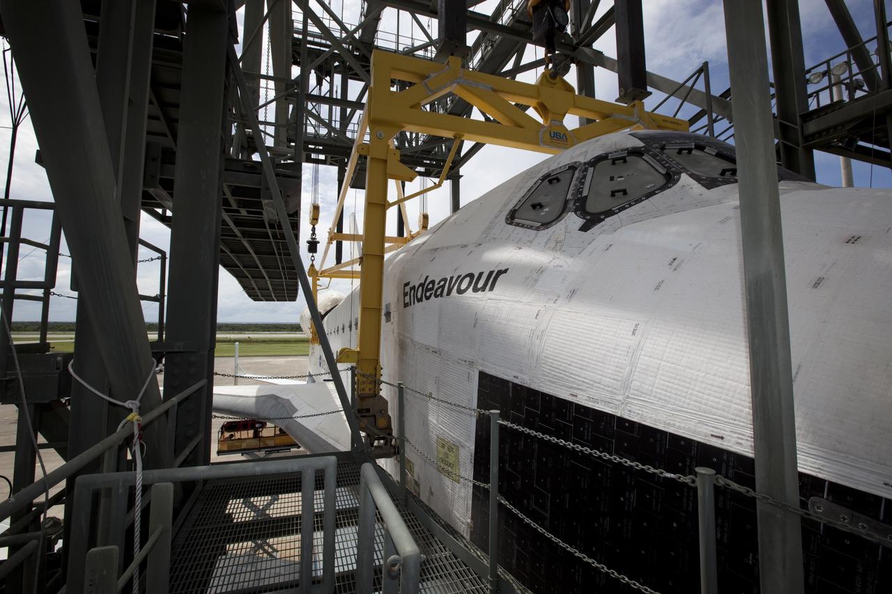 CAPE CANAVERAL, Fla. – Space shuttle Endeavour is lowered onto the Shuttle Carrier Aircraft, or SCA, at the Shuttle Landing Facility at NASA's Kennedy Space Center in Florida. The SCA, a modified 747 jetliner, will fly Endeavour to Los Angeles where it will be placed on public display.  Photo credit: NASA/ Dmitri Gerondidakis