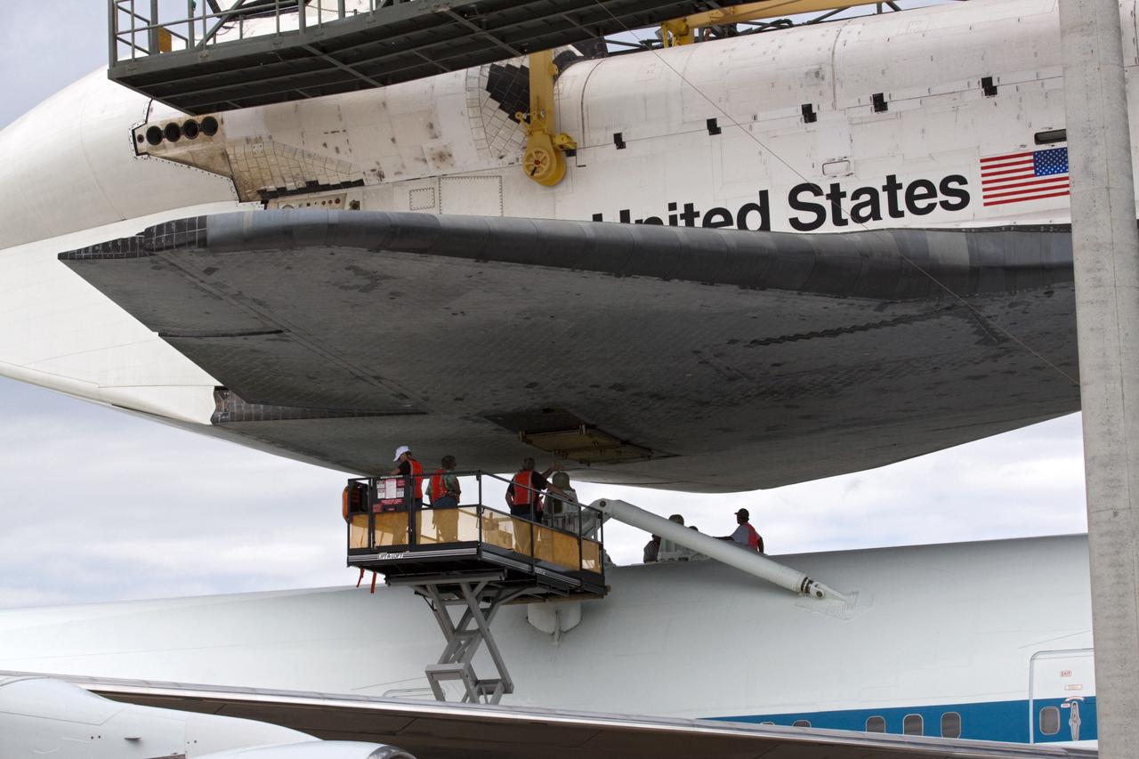 CAPE CANAVERAL, Fla. – Technicians watch as space shuttle Endeavour is lowered onto the Shuttle Carrier Aircraft, or SCA, at the Shuttle Landing Facility at NASA's Kennedy Space Center in Florida. The SCA, a modified 747 jetliner, will fly Endeavour to Los Angeles where it will be placed on public display.  Photo credit: NASA/ Kim Shiflett