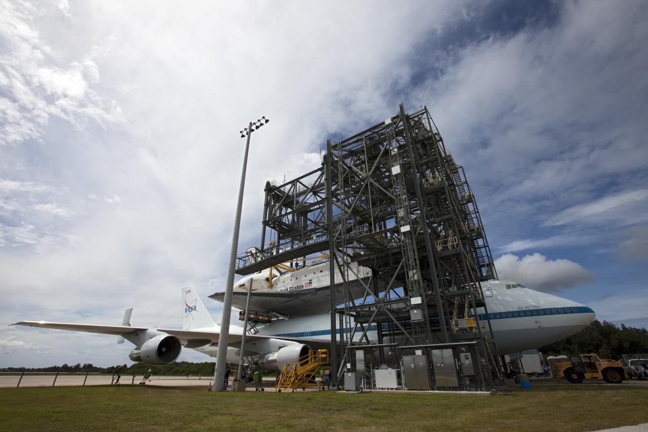 CAPE CANAVERAL, Fla. – Technicians watch as space shuttle Endeavour is lowered onto the Shuttle Carrier Aircraft, or SCA, at the Shuttle Landing Facility at NASA's Kennedy Space Center in Florida. The SCA, a modified 747 jetliner, will fly Endeavour to Los Angeles where it will be placed on public display.  Photo credit: NASA/ Kim Shiflett