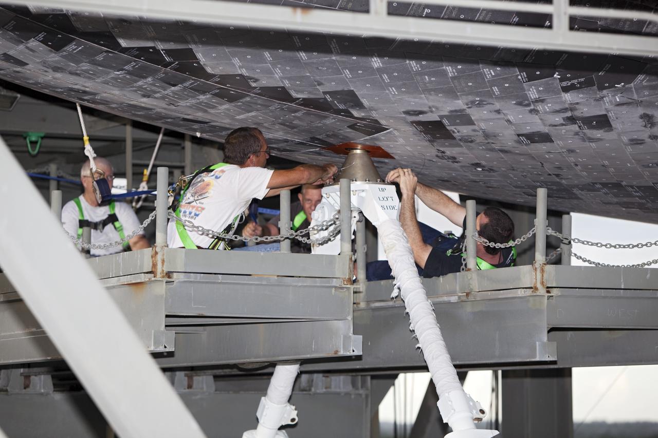 CAPE CANAVERAL, Fla. – At the Shuttle Landing Facility at NASA's Kennedy Space Center in Florida, United Space Alliance technicians work on the mate-demate device checking the forward attach point between the space shuttle Endeavour and NASA's Shuttle Carrier Aircraft, or SCA.      The SCA, a modified 747 jetliner, will fly Endeavour to Los Angeles where it will be placed on public display at the California Science Center. This is the final ferry flight scheduled in the Space Shuttle Program era. For more information on the shuttles' transition and retirement, visit http://www.nasa.gov/transition.  Photo credit: NASA/ Dimitri Gerondidakis