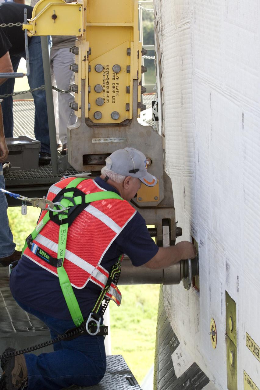 CAPE CANAVERAL, Fla. – While wearing a safety harness, a United Space Alliance technician removes a lift connector used to mount the space shuttle Endeavour to NASA's Shuttle Carrier Aircraft, or SCA. The work is taking place at the Shuttle Landing Facility at NASA's Kennedy Space Center in Florida. The SCA, a modified 747 jetliner, will fly Endeavour to Los Angeles where it will be placed on public display at the California Science Center. This is the final ferry flight scheduled in the Space Shuttle Program era. For more information on the shuttles' transition and retirement, visit http://www.nasa.gov/transition. Photo credit: NASA/Dimitri Gerondidakis