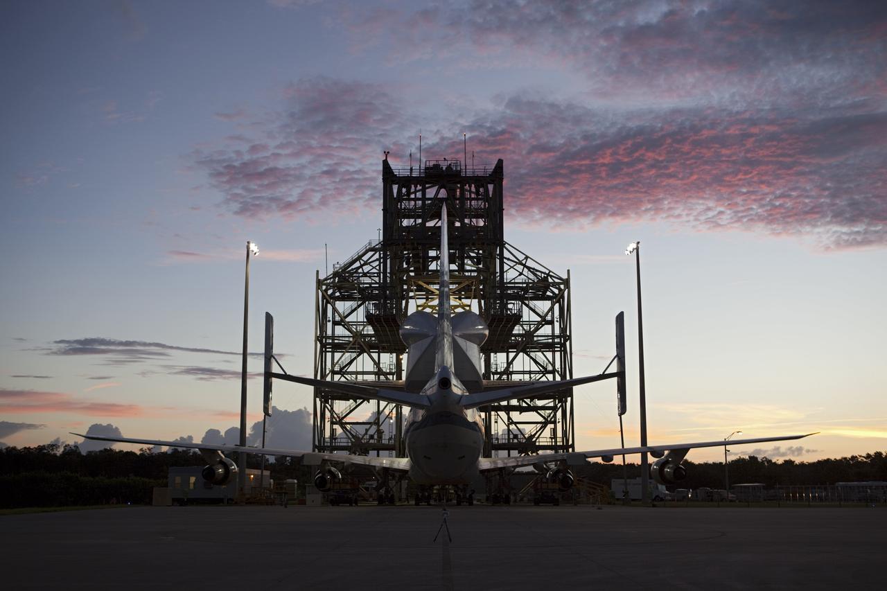 CAPE CANAVERAL, Fla. – The clouds take on a rosy glow as the dawn breaks over the Shuttle Landing Facility at NASA's Kennedy Space Center in Florida.  Preparations are under way to back NASA's Shuttle Carrier Aircraft, or SCA, away from the mate-demate device surrounding it.  Space shuttle Endeavour has been fitted with an aerodynamic tailcone and secured atop the aircraft for its upcoming ferry flight.    The SCA, a modified 747 jetliner, will fly Endeavour to Los Angeles where it will be placed on public display at the California Science Center. This is the final ferry flight scheduled in the Space Shuttle Program era. For more information on the shuttles' transition and retirement, visit http://www.nasa.gov/transition.  Photo credit: NASA/Dimitri Gerondidakis