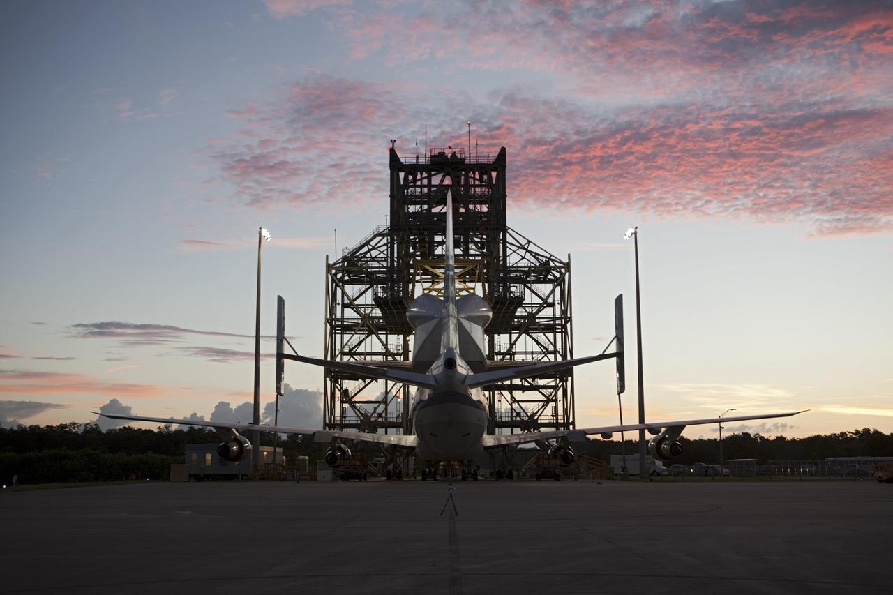 CAPE CANAVERAL, Fla. – The clouds take on a rosy glow as the dawn breaks over the Shuttle Landing Facility at NASA's Kennedy Space Center in Florida.  Preparations are under way to roll NASA's Shuttle Carrier Aircraft, or SCA, away from the mate-demate device surrounding it.  Space shuttle Endeavour has been fitted with an aerodynamic tailcone and secured atop the aircraft for its upcoming ferry flight.    The SCA, a modified 747 jetliner, will fly Endeavour to Los Angeles where it will be placed on public display at the California Science Center. This is the final ferry flight scheduled in the Space Shuttle Program era. For more information on the shuttles' transition and retirement, visit http://www.nasa.gov/transition.  Photo credit: NASA/Dimitri Gerondidakis