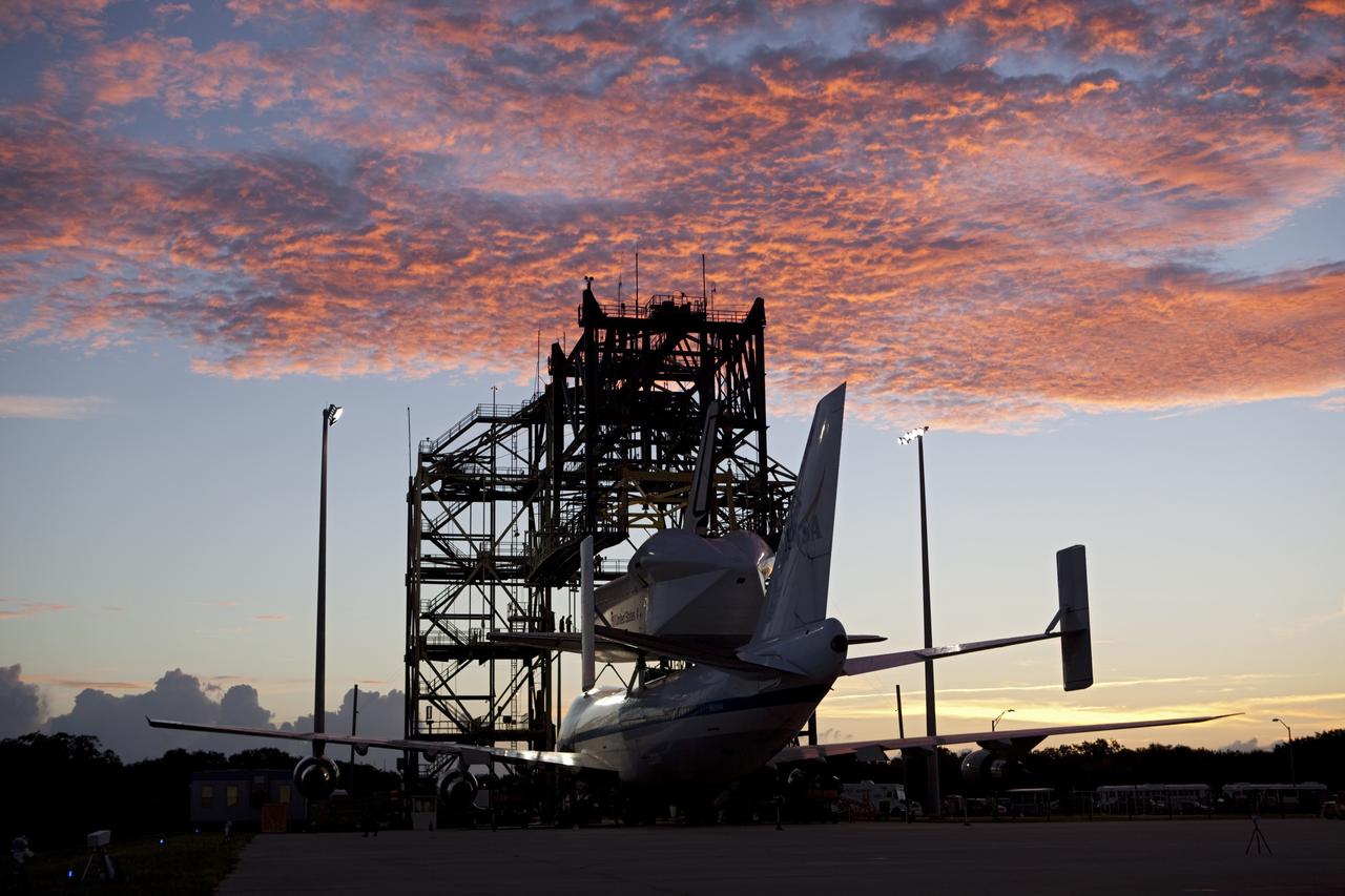 CAPE CANAVERAL, Fla. – The sky is ablaze over the Shuttle Landing Facility at NASA's Kennedy Space Center in Florida. Preparations are under way to roll NASA's Shuttle Carrier Aircraft, or SCA, away from the mate-demate device surrounding it. Space shuttle Endeavour has been fitted with an aerodynamic tailcone and secured atop the aircraft for its upcoming ferry flight. The SCA, a modified 747 jetliner, will fly Endeavour to Los Angeles where it will be placed on public display at the California Science Center. This is the final ferry flight scheduled in the Space Shuttle Program era. For more information on the shuttles' transition and retirement, visit http://www.nasa.gov/transition. Photo credit: NASA/Dimitri Gerondidakis