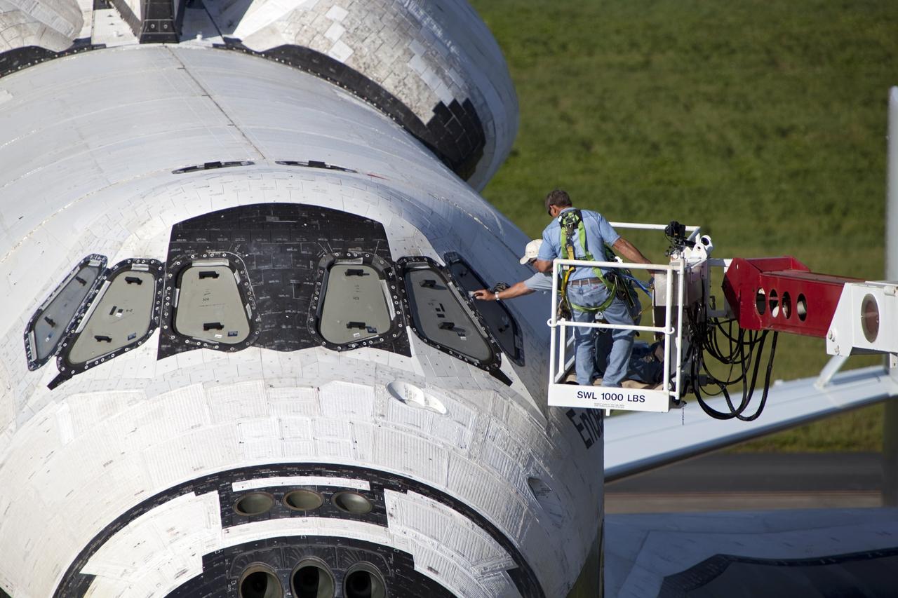 CAPE CANAVERAL, Fla. – United Space Alliance technicians uncover the cockpit windows on space shuttle Endeavour for an employee photo opportunity at the Shuttle Landing Facility at NASA's Kennedy Space Center in Florida.  Endeavour is balanced and secured atop NASA's Shuttle Carrier Aircraft, or SCA.    The SCA, a modified 747 jetliner, will fly Endeavour to Los Angeles where it will be placed on public display at the California Science Center. This is the final ferry flight scheduled in the Space Shuttle Program era. For more information on the shuttles' transition and retirement, visit http://www.nasa.gov/transition.  Photo credit: NASA/Dimitri Gerondidakis