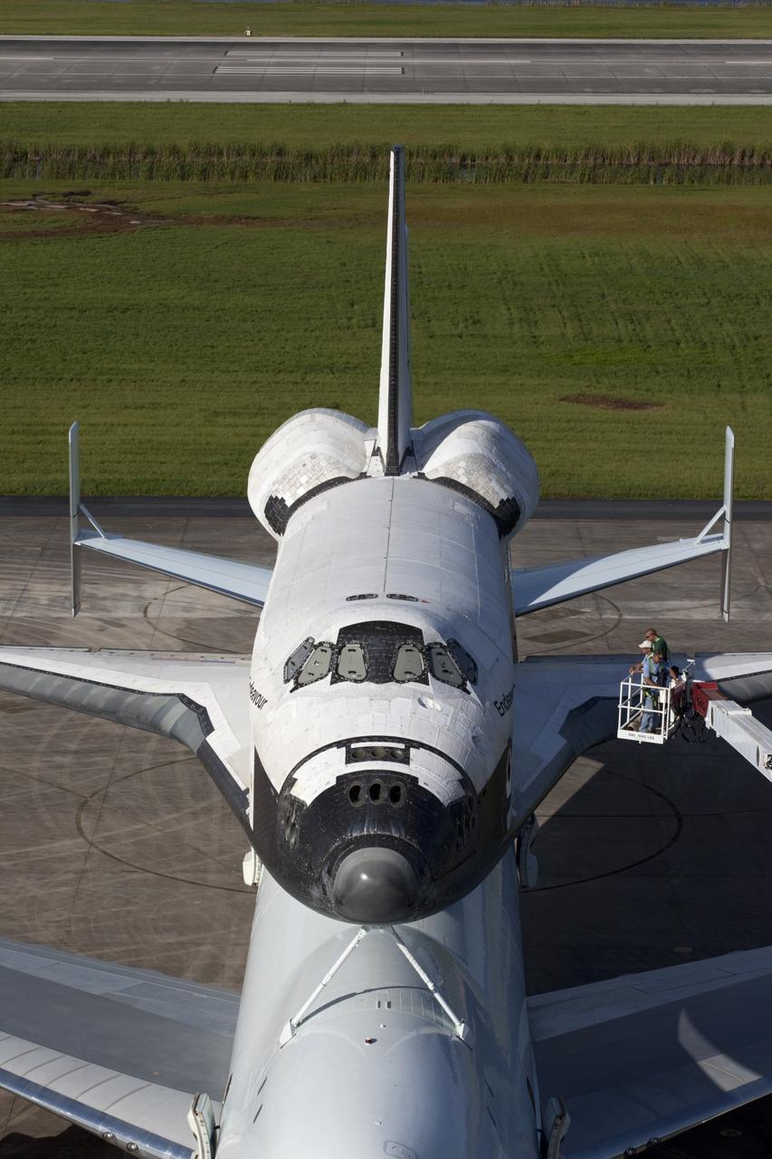 CAPE CANAVERAL, Fla. – United Space Alliance technicians prepare to uncover the cockpit windows on space shuttle Endeavour for an employee photo opportunity at the Shuttle Landing Facility at NASA's Kennedy Space Center in Florida.  Endeavour is balanced and secured atop NASA's Shuttle Carrier Aircraft, or SCA.    The SCA, a modified 747 jetliner, will fly Endeavour to Los Angeles where it will be placed on public display at the California Science Center. This is the final ferry flight scheduled in the Space Shuttle Program era. For more information on the shuttles' transition and retirement, visit http://www.nasa.gov/transition.  Photo credit: NASA/Kim Shiflett