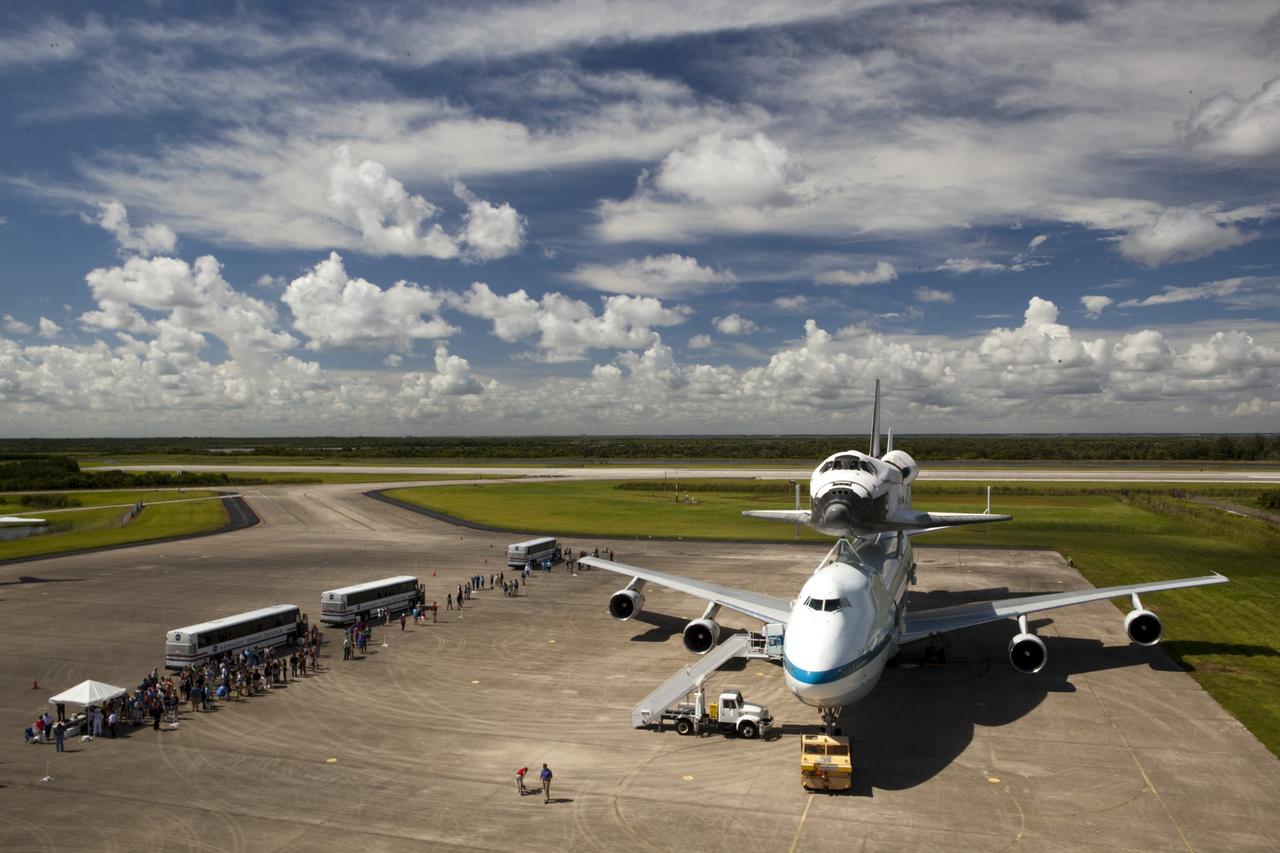 CAPE CANAVERAL, Fla. – At the Shuttle Landing Facility at NASA's Kennedy Space Center in Florida, guests arrive by bus to view the space shuttle Endeavour, mounted atop NASA's Shuttle Carrier Aircraft, or SCA, as preparations continue for the ferry flight to California.      The SCA, a modified 747 jetliner, will fly Endeavour to Los Angeles where it will be placed on public display at the California Science Center. This is the final ferry flight scheduled in the Space Shuttle Program era. For more information on the shuttles' transition and retirement, visit http://www.nasa.gov/transition.  Photo credit: NASA/ Dimitri Gerondidakis