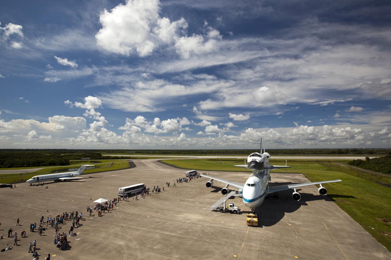 CAPE CANAVERAL, Fla. – At the Shuttle Landing Facility at NASA's Kennedy Space Center in Florida, guests arrive by bus to view the space shuttle Endeavour, mounted atop NASA's Shuttle Carrier Aircraft, or SCA, as preparations continue for the ferry flight to California.    The SCA, a modified 747 jetliner, will fly Endeavour to Los Angeles where it will be placed on public display at the California Science Center. This is the final ferry flight scheduled in the Space Shuttle Program era. For more information on the shuttles' transition and retirement, visit http://www.nasa.gov/transition.  Photo credit: NASA/ Dimitri Gerondidakis