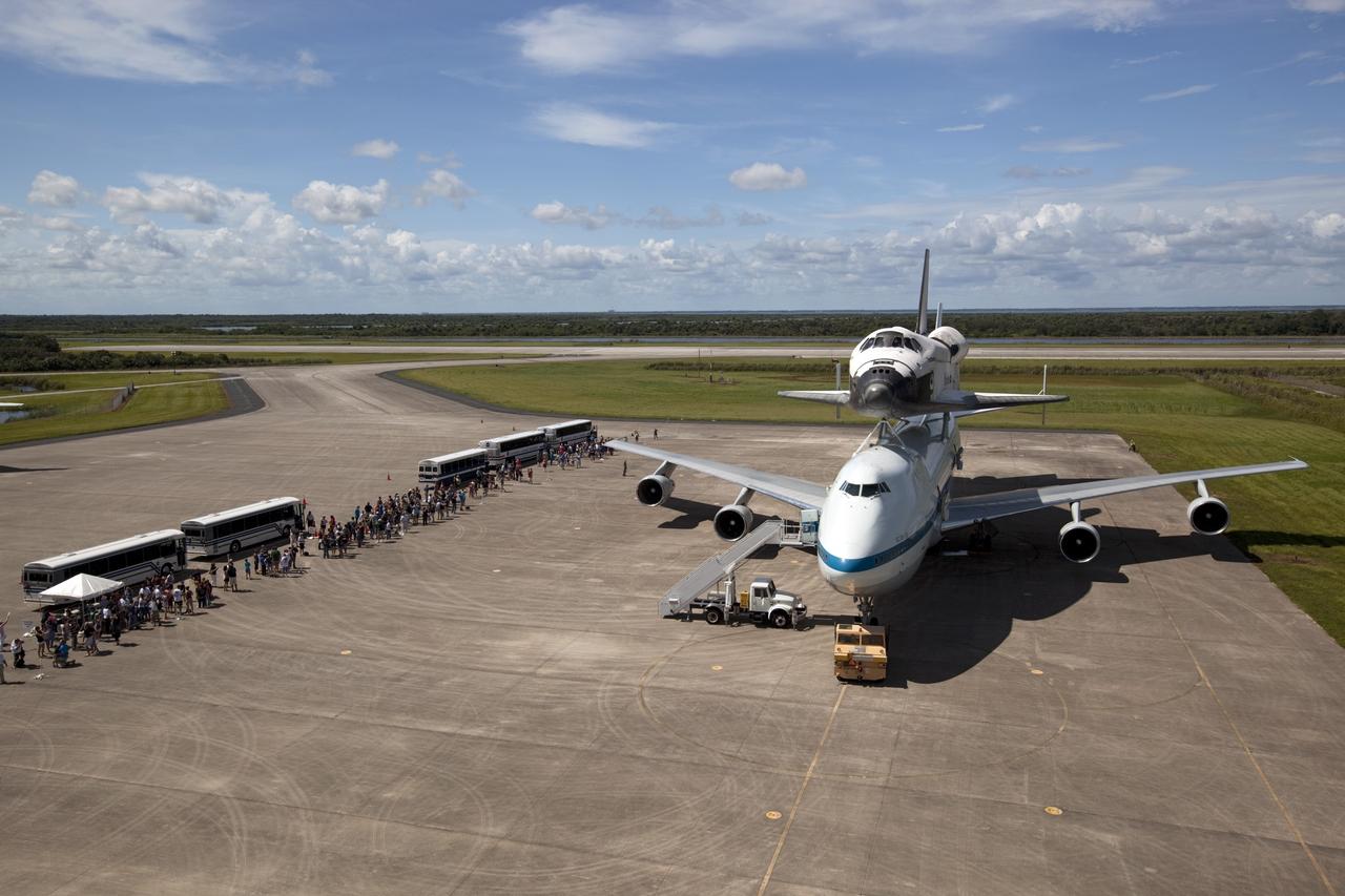 CAPE CANAVERAL, Fla. – At the Shuttle Landing Facility at NASA's Kennedy Space Center in Florida, guests arrive by bus to view the space shuttle Endeavour, mounted atop NASA's Shuttle Carrier Aircraft, or SCA, as preparations continue for the ferry flight to California.    The SCA, a modified 747 jetliner, will fly Endeavour to Los Angeles where it will be placed on public display at the California Science Center. This is the final ferry flight scheduled in the Space Shuttle Program era. For more information on the shuttles' transition and retirement, visit http://www.nasa.gov/transition.  Photo credit: NASA/ Dimitri Gerondidakis
