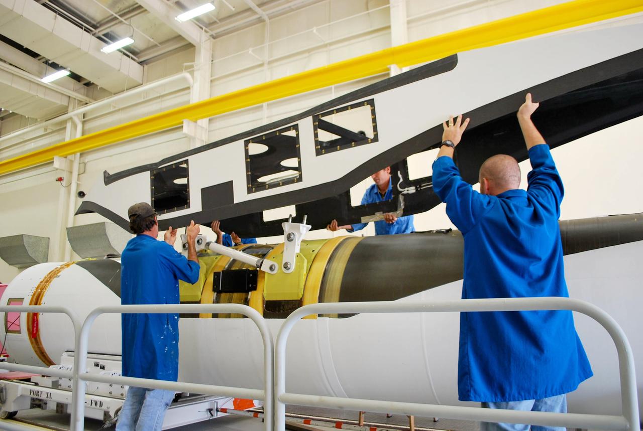 VANDENBERG AFB, Calif. – Technicians perform a fit check on an Orbital Sciences Pegasus rocket as the launcher is processed for the Interface Region Imaging Spectrograph mission known as IRIS. The technicians are attaching the portion of the Pegasus that joins the wing to the fuselage, a piece called a fillet. Photo credit: VAFB/Randy Beaudoin