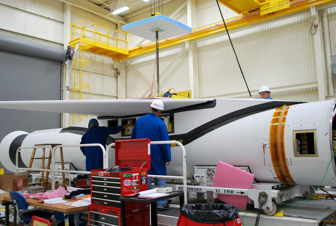 VANDENBERG AFB, Calif. – Technicians perform a fit check on an Orbital Sciences Pegasus rocket as the launcher is processed for the Interface Region Imaging Spectrograph mission known as IRIS. The technicians are attaching the wing of the Pegasus to the fuselage. Photo credit: VAFB/Randy Beaudoin