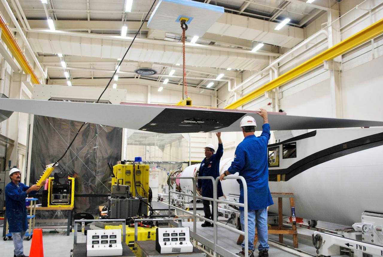 VANDENBERG AFB, Calif. – Technicians perform a fit check on an Orbital Sciences Pegasus rocket as the launcher is processed for the Interface Region Imaging Spectrograph mission known as IRIS. The technicians are attaching the wing of the Pegasus to the fuselage. Photo credit: VAFB/Randy Beaudoin