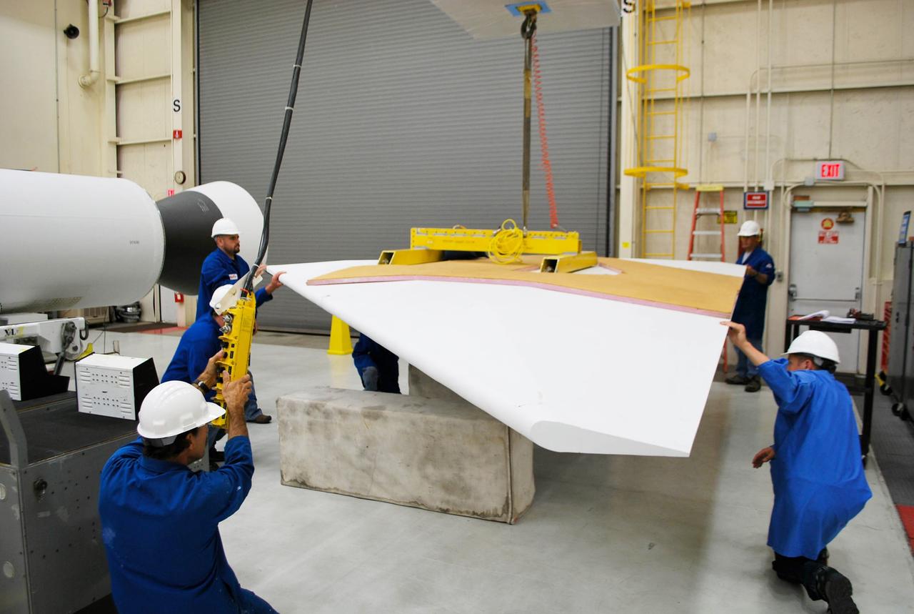 VANDENBERG AFB, Calif. – Technicians perform a fit check on an Orbital Sciences Pegasus rocket as the launcher is processed for the Interface Region Imaging Spectrograph mission known as IRIS. The technicians are attaching the wing of the Pegasus to the fuselage. Photo credit: VAFB/Randy Beaudoin