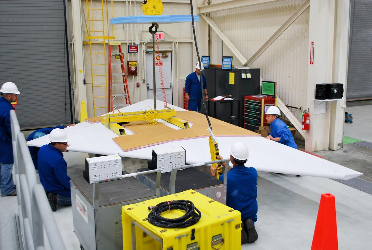 VANDENBERG AFB, Calif. – Technicians perform a fit check on an Orbital Sciences Pegasus rocket as the launcher is processed for the Interface Region Imaging Spectrograph mission known as IRIS. The technicians are attaching the wing of the Pegasus to the fuselage. Photo credit: VAFB/Randy Beaudoin