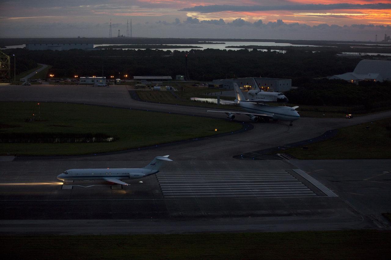 CAPE CANAVERAL, Fla. – At the Shuttle Landing Facility at NASA's Kennedy Space Center in Florida, a pathfinder aircraft, in the foreground, prepares to take off. The pathfinder will fly ahead of NASA's Shuttle Carrier Aircraft, or SCA, with the space shuttle Endeavour mounted atop, also preparing to taxi away from the mate-demate device for its ferry flight to California.    The SCA, a modified 747 jetliner, will fly Endeavour to Los Angeles where it will be placed on public display at the California Science Center. This is the final ferry flight scheduled in the Space Shuttle Program era. For more information on the shuttles' transition and retirement, visit http://www.nasa.gov/transition.  Photo credit: NASA/Kim Shiflett