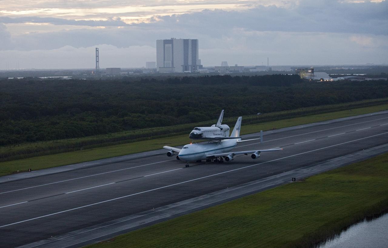 CAPE CANAVERAL, Fla. – At the Shuttle Landing Facility at NASA's Kennedy Space Center in Florida, NASA's Shuttle Carrier Aircraft, or SCA, with the space shuttle Endeavour, mounted atop taxis down the runway for its ferry flight to California. The Vehicle Assembly Building can be seen in the background.    The SCA, a modified 747 jetliner, will fly Endeavour to Los Angeles where it will be placed on public display at the California Science Center. This is the final ferry flight scheduled in the Space Shuttle Program era. For more information on the shuttles' transition and retirement, visit http://www.nasa.gov/transition.  Photo credit: NASA/Kim Shiflett