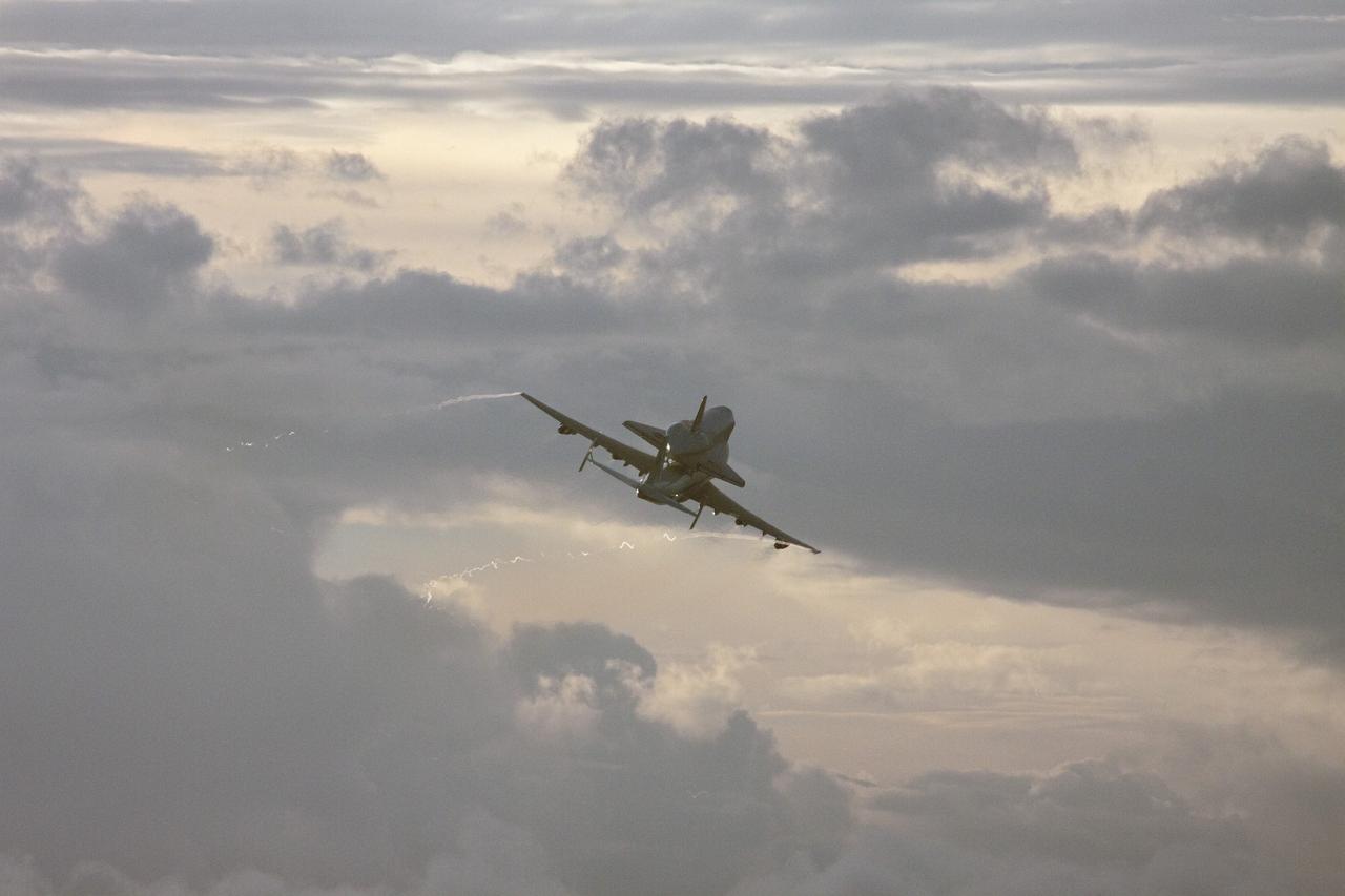 CAPE CANAVERAL, Fla. – At NASA's Kennedy Space Center in Florida, NASA's Shuttle Carrier Aircraft, or SCA, with the space shuttle Endeavour mounted atop, prepares to make a low-level pass over the Shuttle Landing Facility. The shuttle-SCA combination will then head west for its ferry flight to California.      The SCA, a modified 747 jetliner, will fly Endeavour to Los Angeles where it will be placed on public display at the California Science Center. This is the final ferry flight scheduled in the Space Shuttle Program era. For more information on the shuttles' transition and retirement, visit http://www.nasa.gov/transition.  Photo credit: NASA/Jim Grossmann