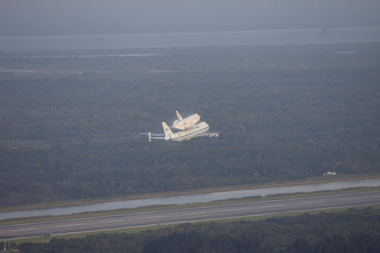 CAPE CANAVERAL, Fla. – At NASA's Kennedy Space Center in Florida, NASA's Shuttle Carrier Aircraft, or SCA, with the space shuttle Endeavour mounted atop, makes a low-level pass over the Shuttle Landing Facility. Following behind the SCA-shuttle combination is a T-38 chase aircraft. After making several low-level passes over several locations on Florida's Space Coast the SCA-Shuttle will head west for its ferry flight to California.      The SCA, a modified 747 jetliner, will fly Endeavour to Los Angeles where it will be placed on public display at the California Science Center. This is the final ferry flight scheduled in the Space Shuttle Program era. For more information on the shuttles' transition and retirement, visit http://www.nasa.gov/transition.  Photo credit: NASA/Jim Grossmann