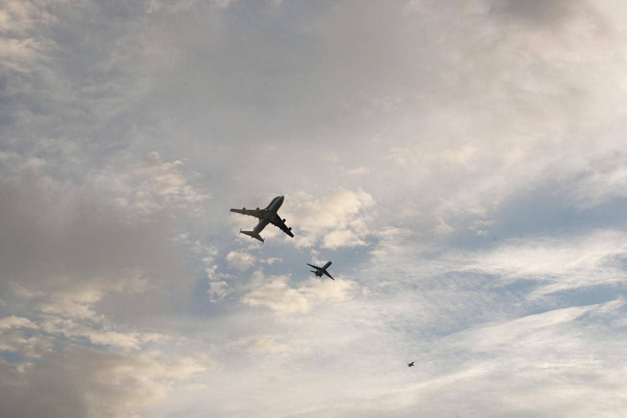 COCOA BEACH, Fla. – NASA's Shuttle Carrier Aircraft, or SCA, with the space shuttle Endeavour mounted atop, left, is accompanied by its pathfinder aircraft, center, and a T-38 chase aircraft flying along Cocoa Beach. The SCA, a modified 747 jetliner, will fly Endeavour to Los Angeles where it will be placed on public display at the California Science Center. This is the final ferry flight scheduled in the Space Shuttle Program era. For more information on the shuttles' transition and retirement, visit http://www.nasa.gov/transition. Photo credit: NASA/Alan Ault