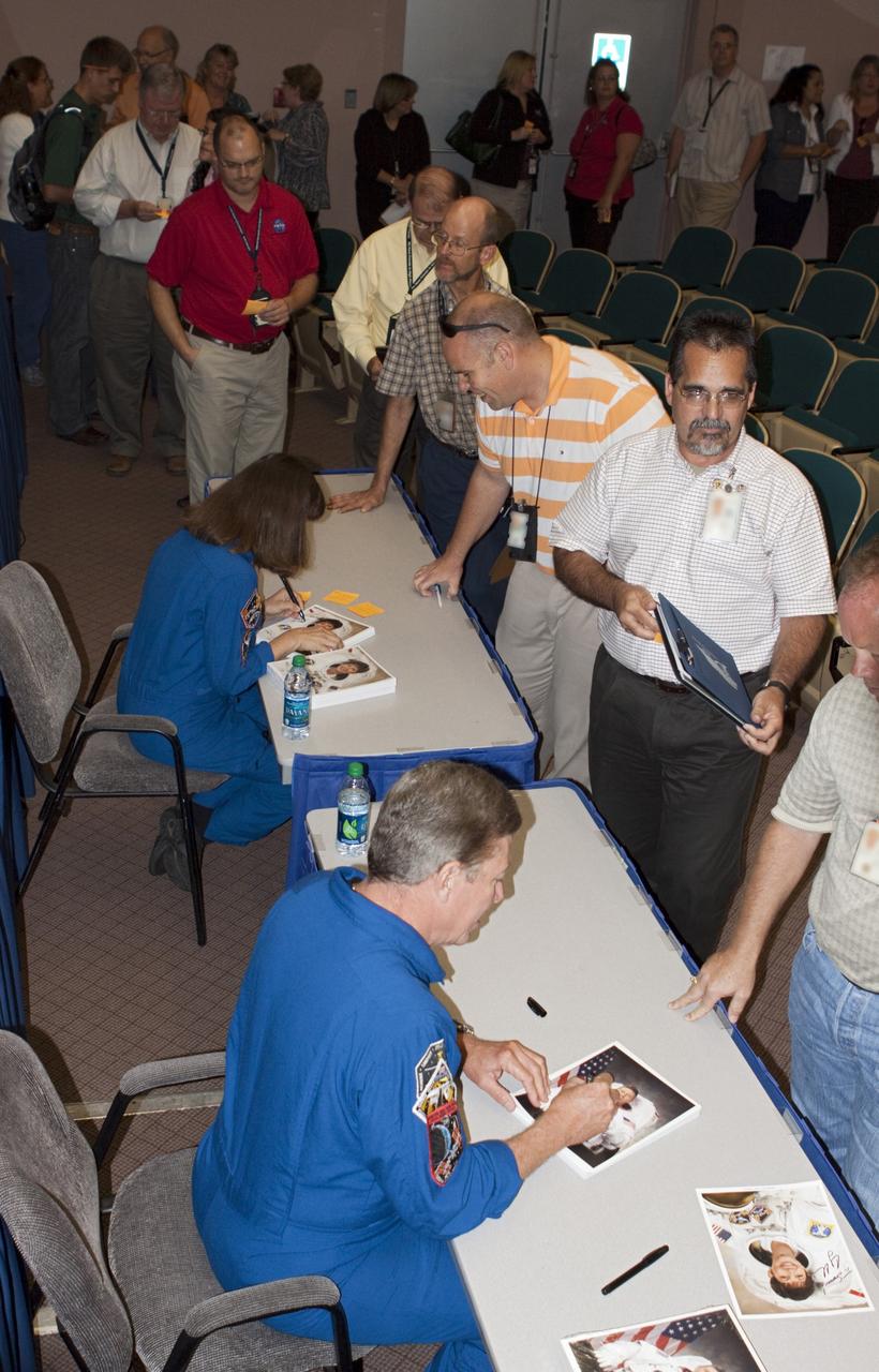 CAPE CANAVERAL, Fla. –NASA astronauts Mike Fossum and Catherine Coleman sign autographs for Kennedy Space Center employees after speaking about their experiences aboard the International Space Station. Coleman spent 159 days aboard the station during expeditions 26 and 27. During expeditions 28 and 29, Fossum was in space for 167 days. For more information on the space station, visit http://www.nasa.gov/mission_pages/station/expeditions/index.html Photo credit: NASA/Gianni Woods