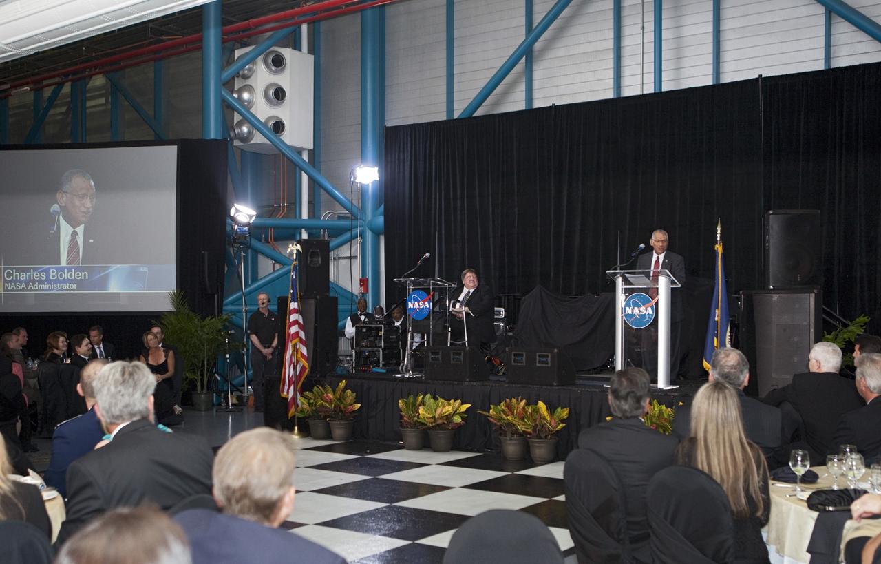 CAPE CANAVERAL, Fla. – NASA Administrator Charlie Bolden speaks to attendees during Kennedy Space Center’s 50th Anniversary Gala event at the Kennedy Space Center Visitor Complex Apollo/Saturn V Center in Florida. At left, on stage, is Master of Ceremony Jim Banke. The gala was coordinated by Kennedy and the National Space Club Florida Committee with the theme, “Celebrating the Past and Preparing for the Future.”     The event was attended by about 650 current and retired NASA and contractor workers, dignitaries, and several former Kennedy Space Center directors. Photo credit: NASA/Kim Shiflett