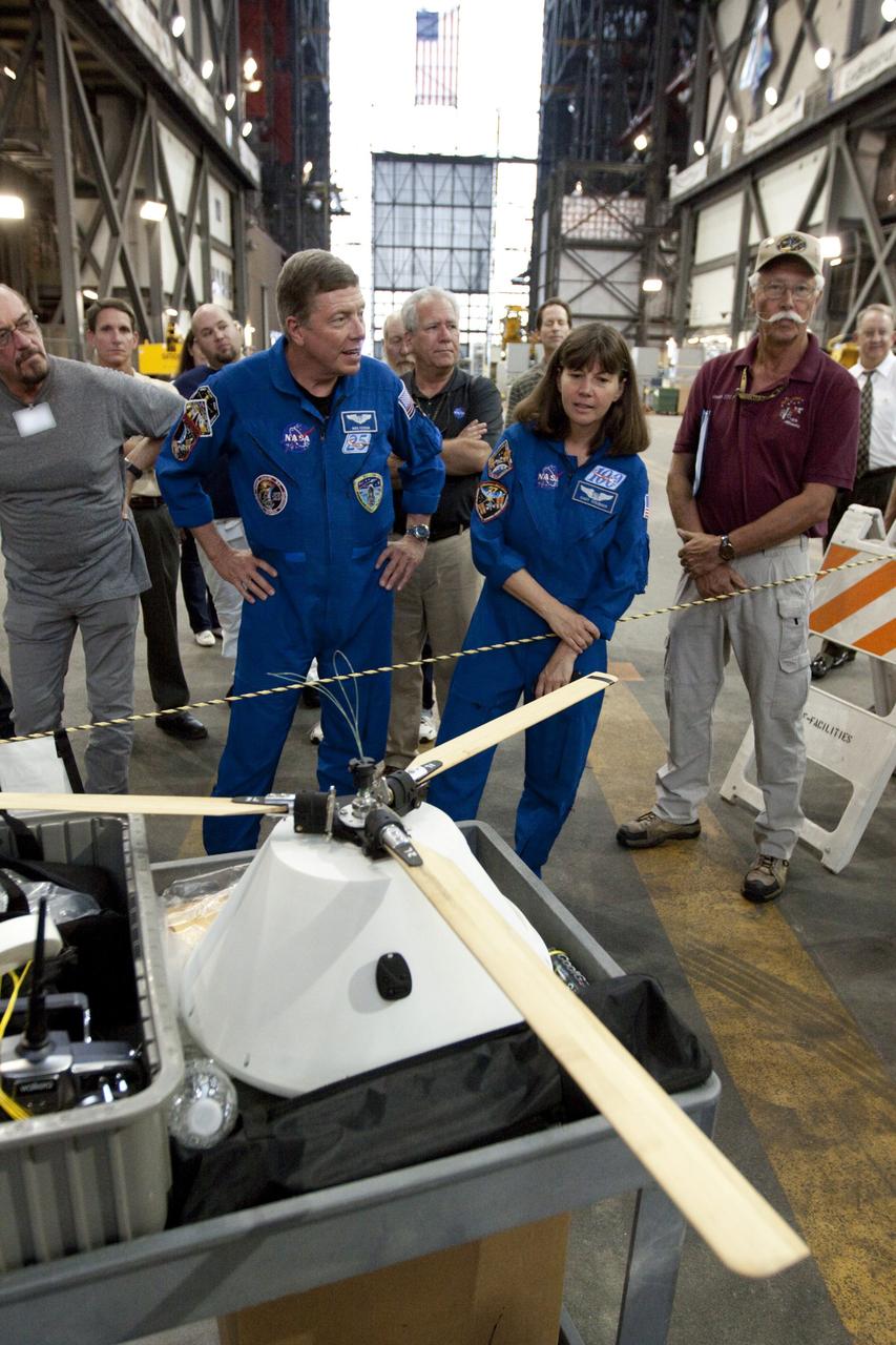 CAPE CANAVERAL, Fla. - Astronauts Mike Fossum and Cady Coleman look over a model capsule fit with rotor blades ahead of tests inside the Vehicle Assembly Building at NASA's Kennedy Space Center in Florida. The design would give a capsule the stability and control of a helicopter, but would not be powered. Instead, the wind passing over the rotors as the capsule descends would make the blades turn, a process called auto-rotation. The intent is to give real spacecraft a soft landing with enough control that they could touch down anywhere in the world, whether it be a runway or parking lot. In other words, wherever a helicopter could land, a spacecraft could land, too. Photo credit: NASA/Kim Shiflett